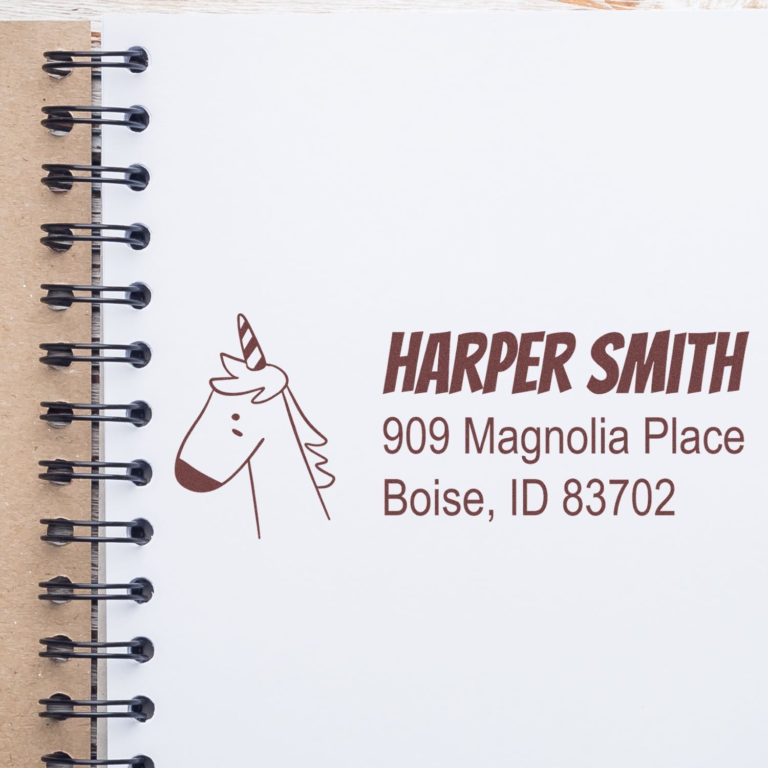 Custom unicorn rubber stamp with Harper Smith return address, Boise, ID, on a spiral notebook page.