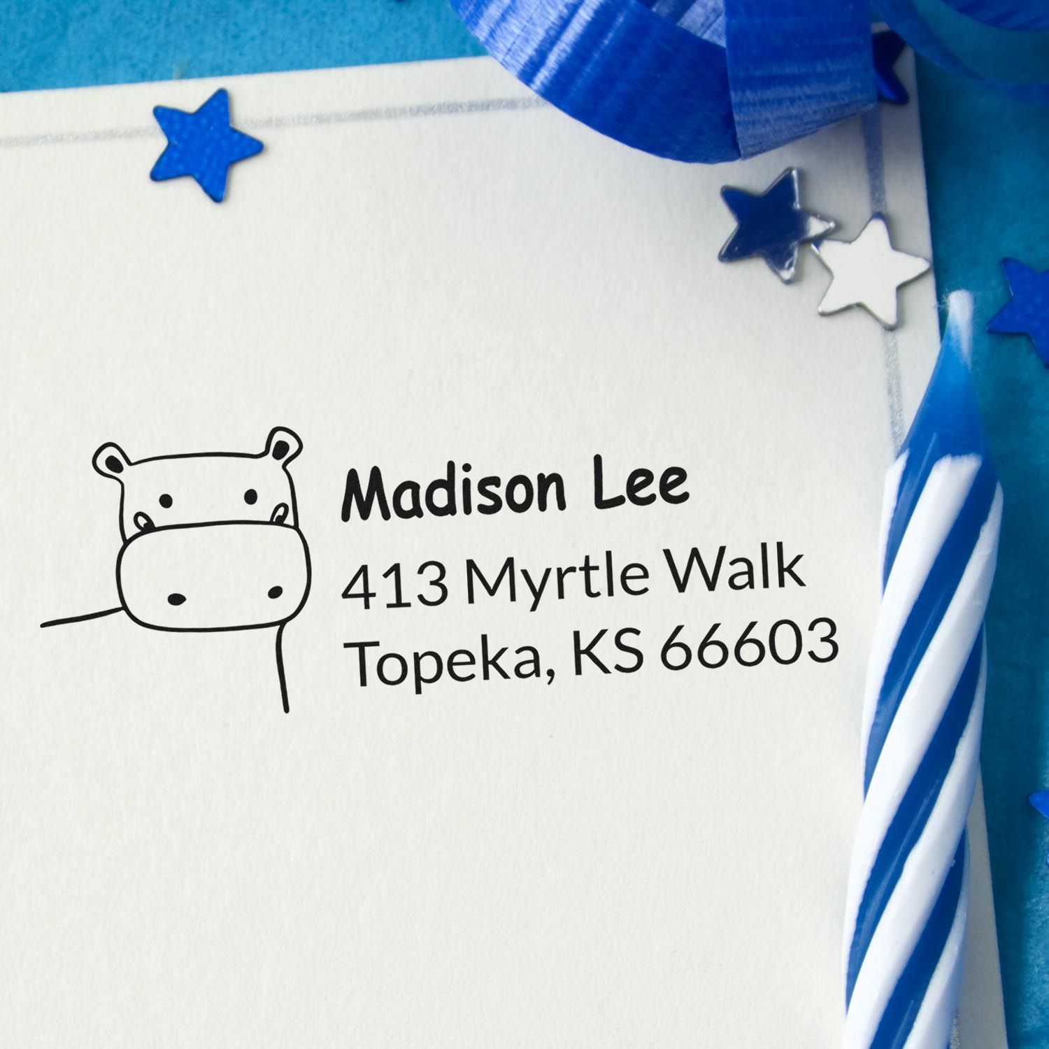 Custom rubber address stamp with hippo icon and name/address for personalized return addressing on envelopes.
