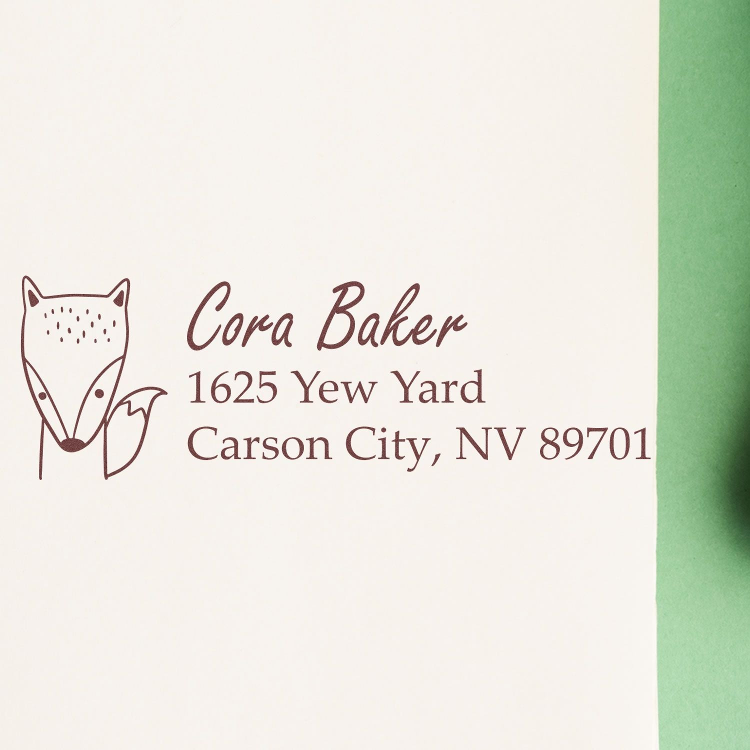 Personalized rubber stamp with fox logo and return address for Cora Baker in Carson City, NV 89701.