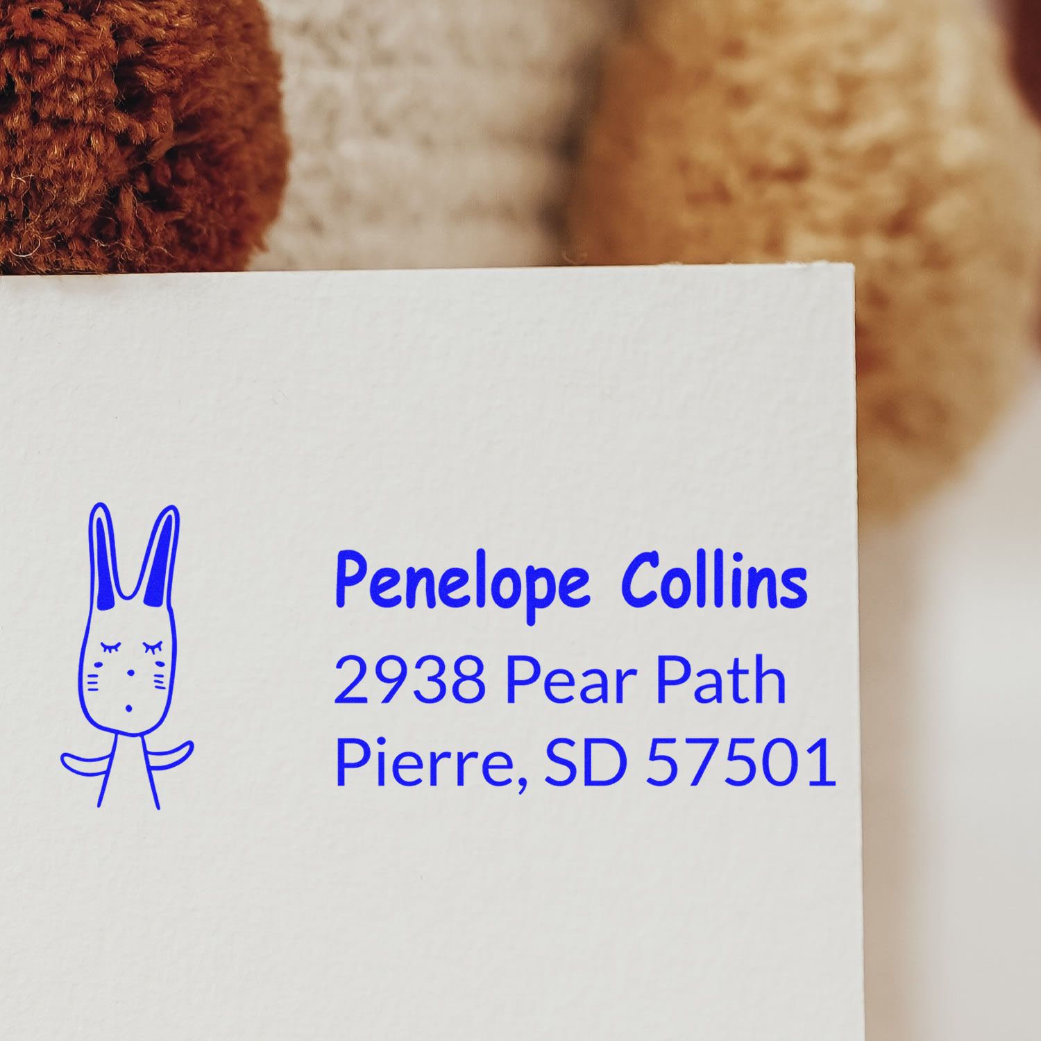 Custom rabbit address rubber stamp in blue ink, featuring Penelope Collins mailing details for quick envelope labeling.