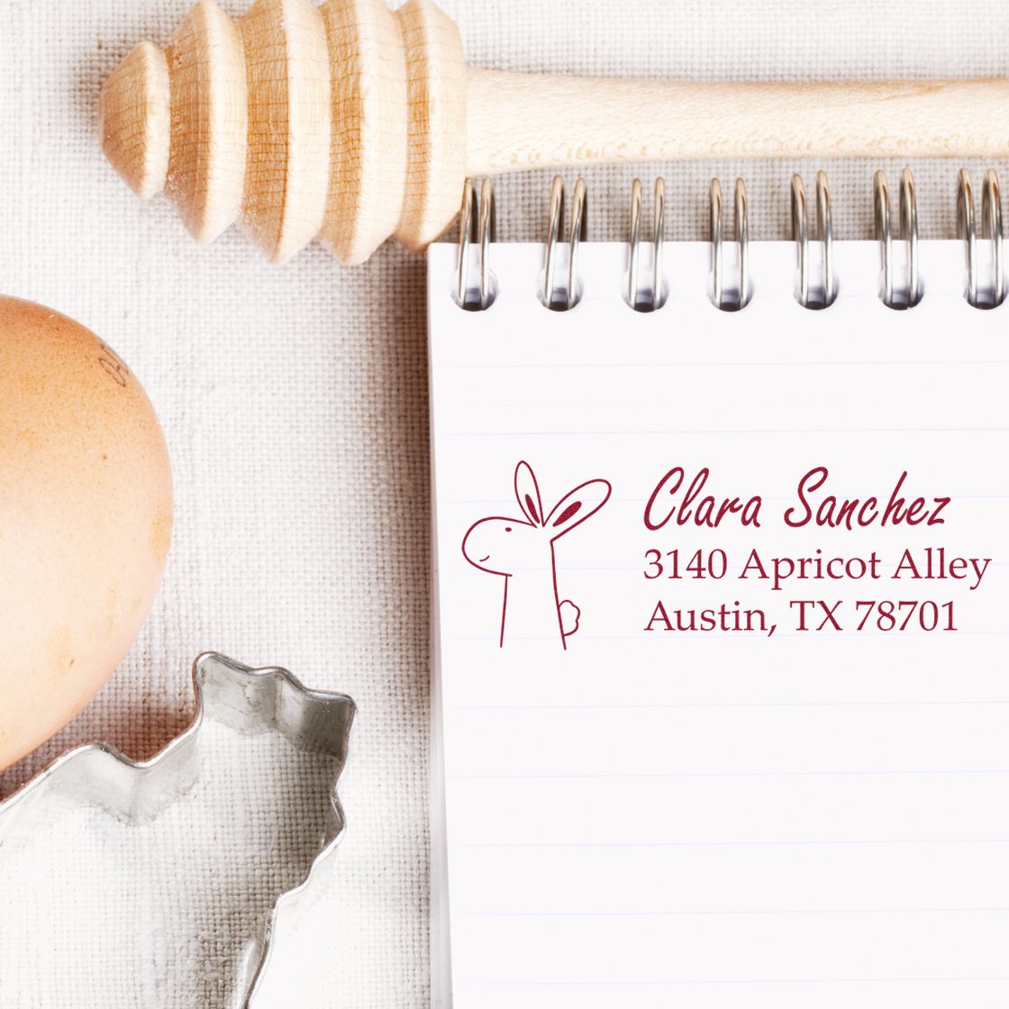 Custom rubber stamp with bunny logo and return address on notepad for personalized mailing and packaging.