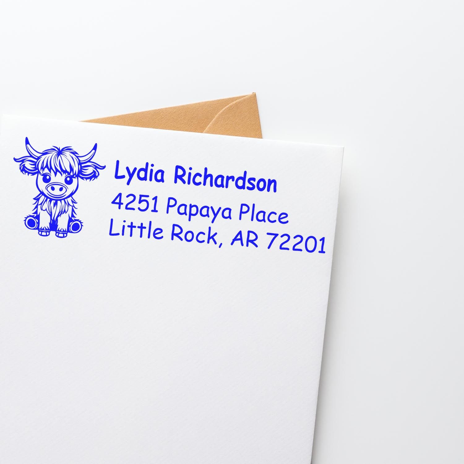 Custom rubber return address stamp with cow design for Lydia Richardson, Little Rock, AR on a white envelope.