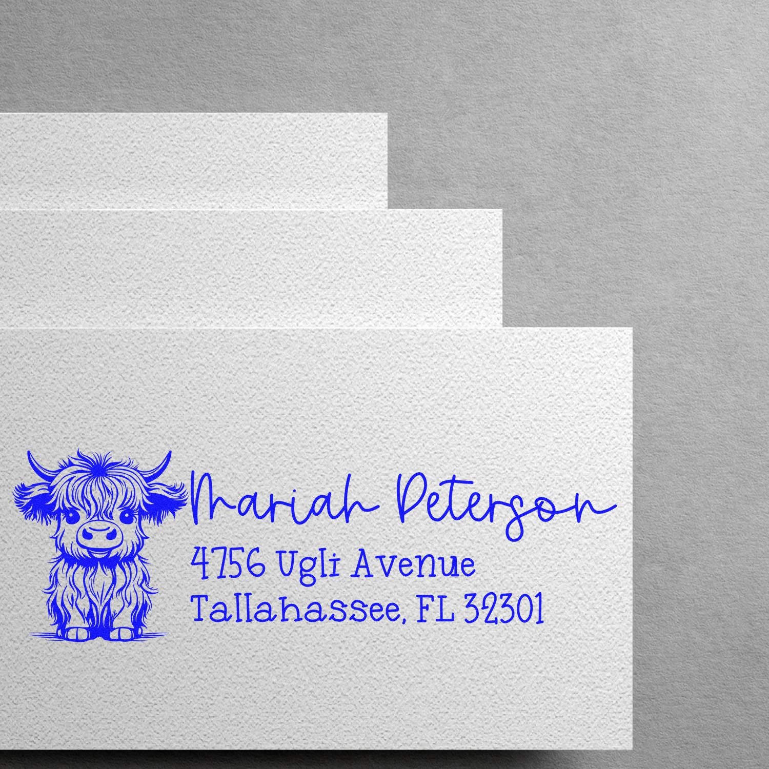 Custom rubber address stamp with blue highland cow design for Mariah Peterson, Tallahassee, FL return address.