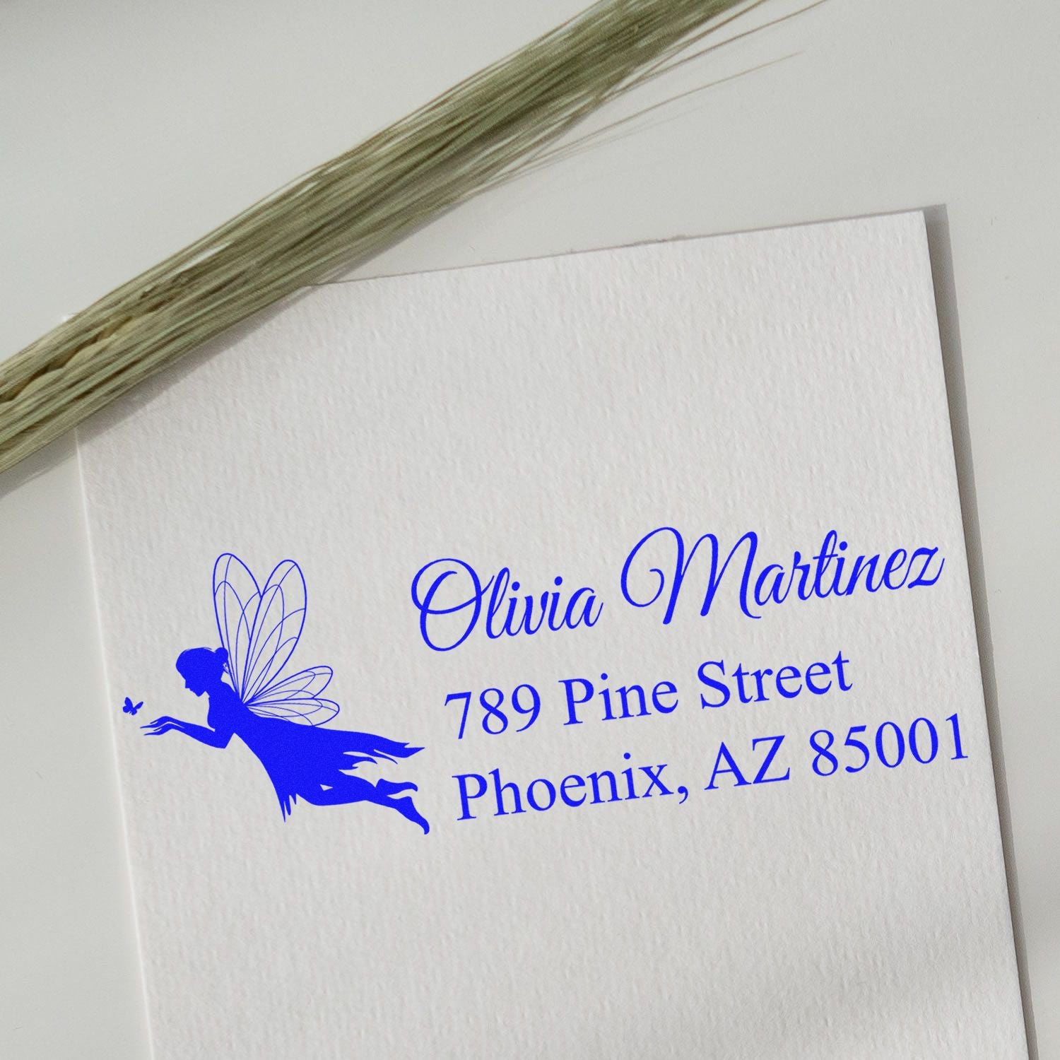 Custom fairy return address rubber stamp with name and address printed in blue on white card.