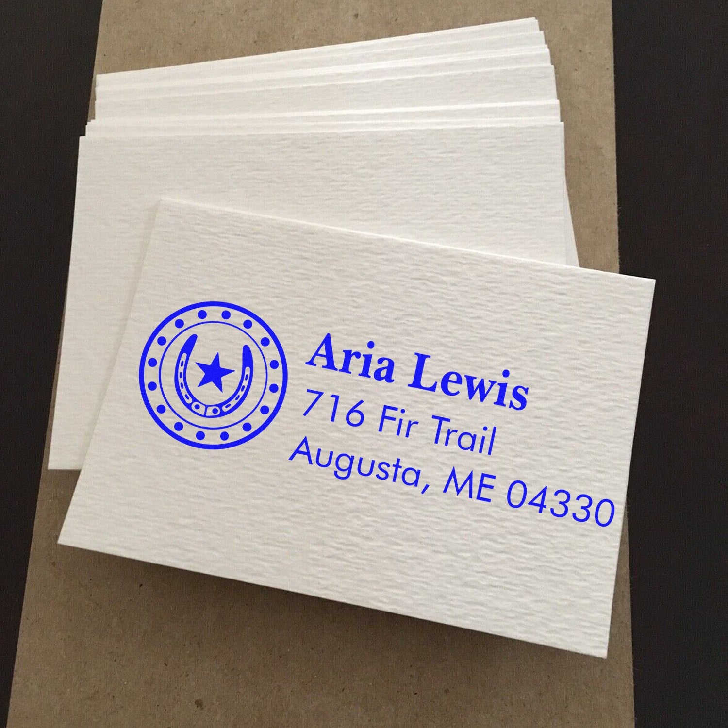 Custom rubber address stamp sample with horseshoe logo for Aria Lewis, used for personalized return address labeling.