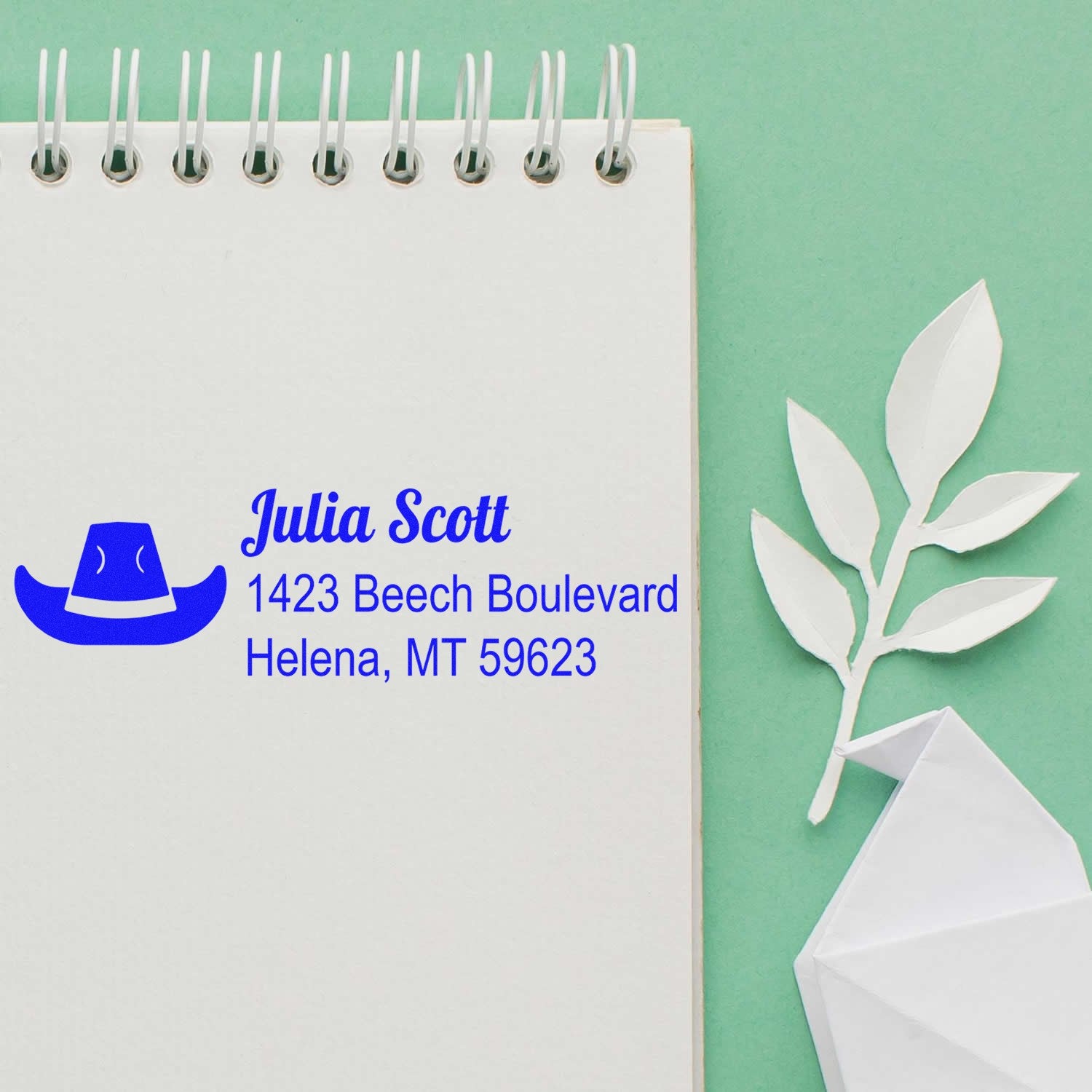 Custom return address rubber stamp with name, address and hat logo on notebook page for envelopes and stationery.