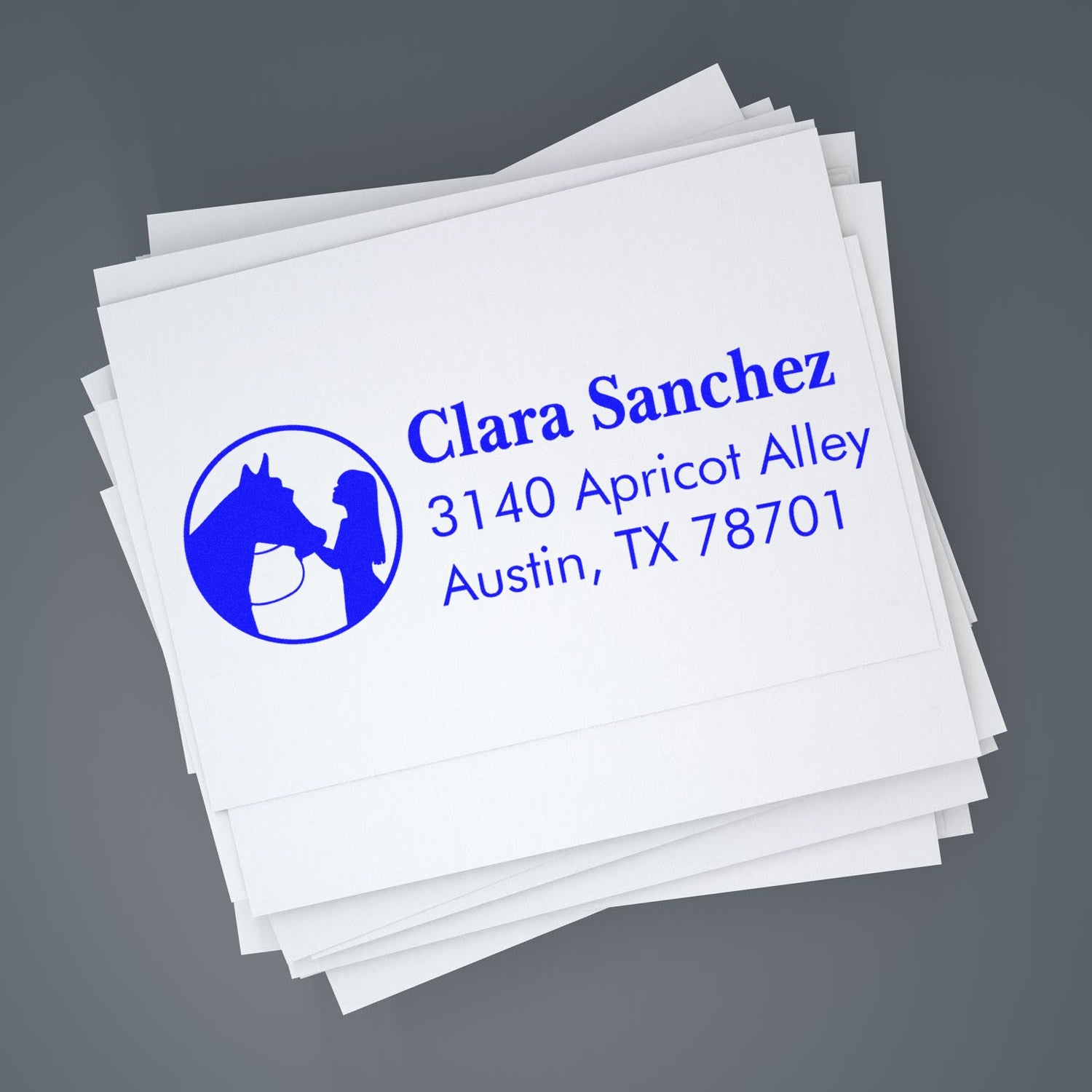 Custom return address rubber stamp with horse logo for Clara Sanchez, Austin TX, on stacked envelopes.