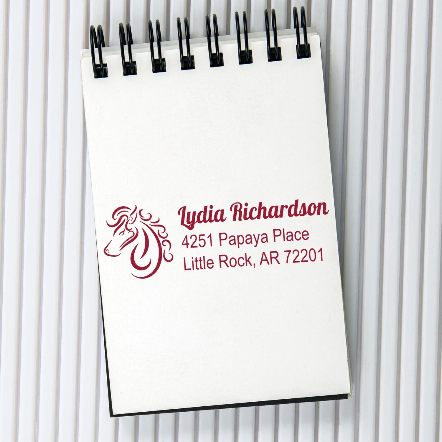 Custom horse logo address stamp imprint on notepad with name and return address, ideal for personalized rubber stamps.