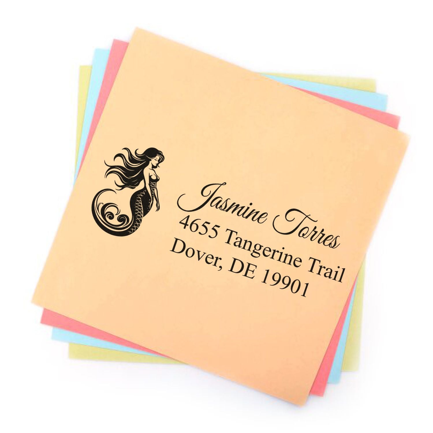 Custom mermaid address rubber stamp with personalized name and address on pastel paper sheets.