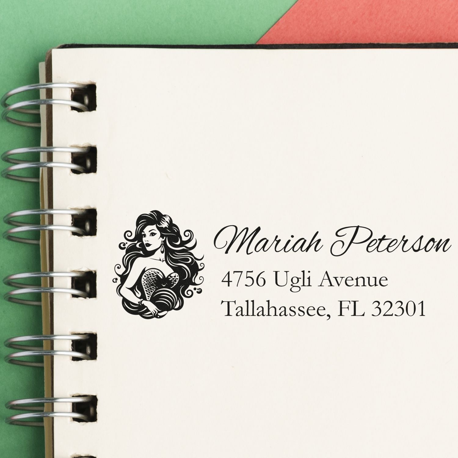 Personalized mermaid address rubber stamp for Mariah Peterson, Tallahassee FL, stamped on a notebook page.