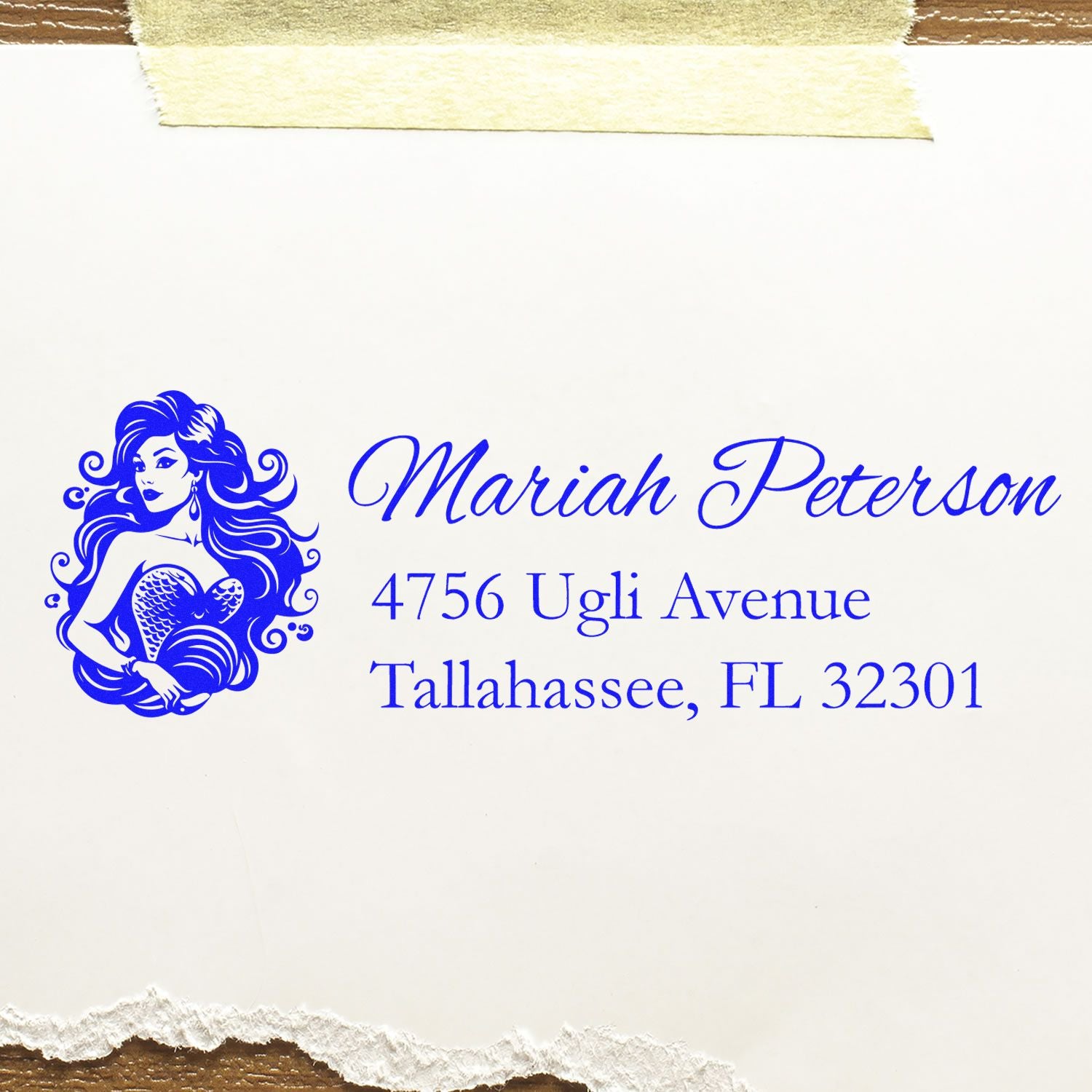 Custom mermaid return address rubber stamp with name and Tallahassee, FL address in blue script.