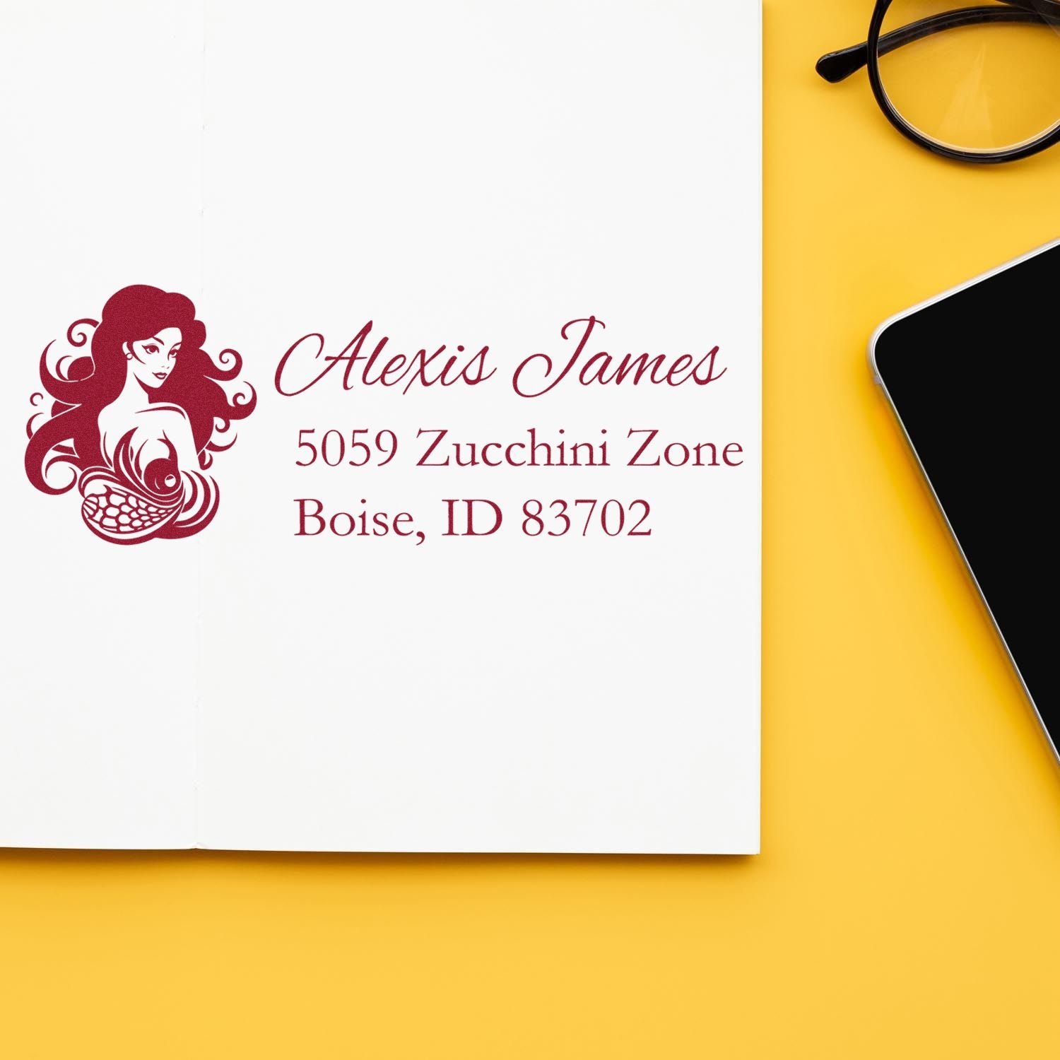 Custom rubber address stamp with mermaid logo for Alexis James, featuring Boise, ID return address on a notebook.