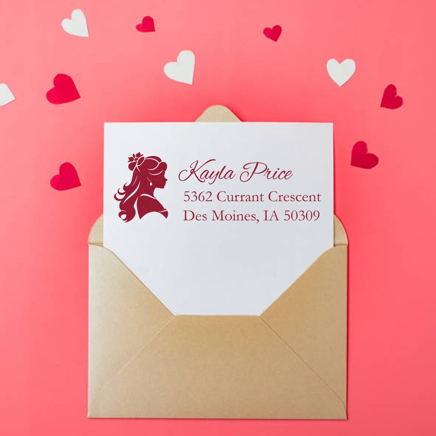 Personalized return address rubber stamp on wedding envelope with heart accents and feminine silhouette.