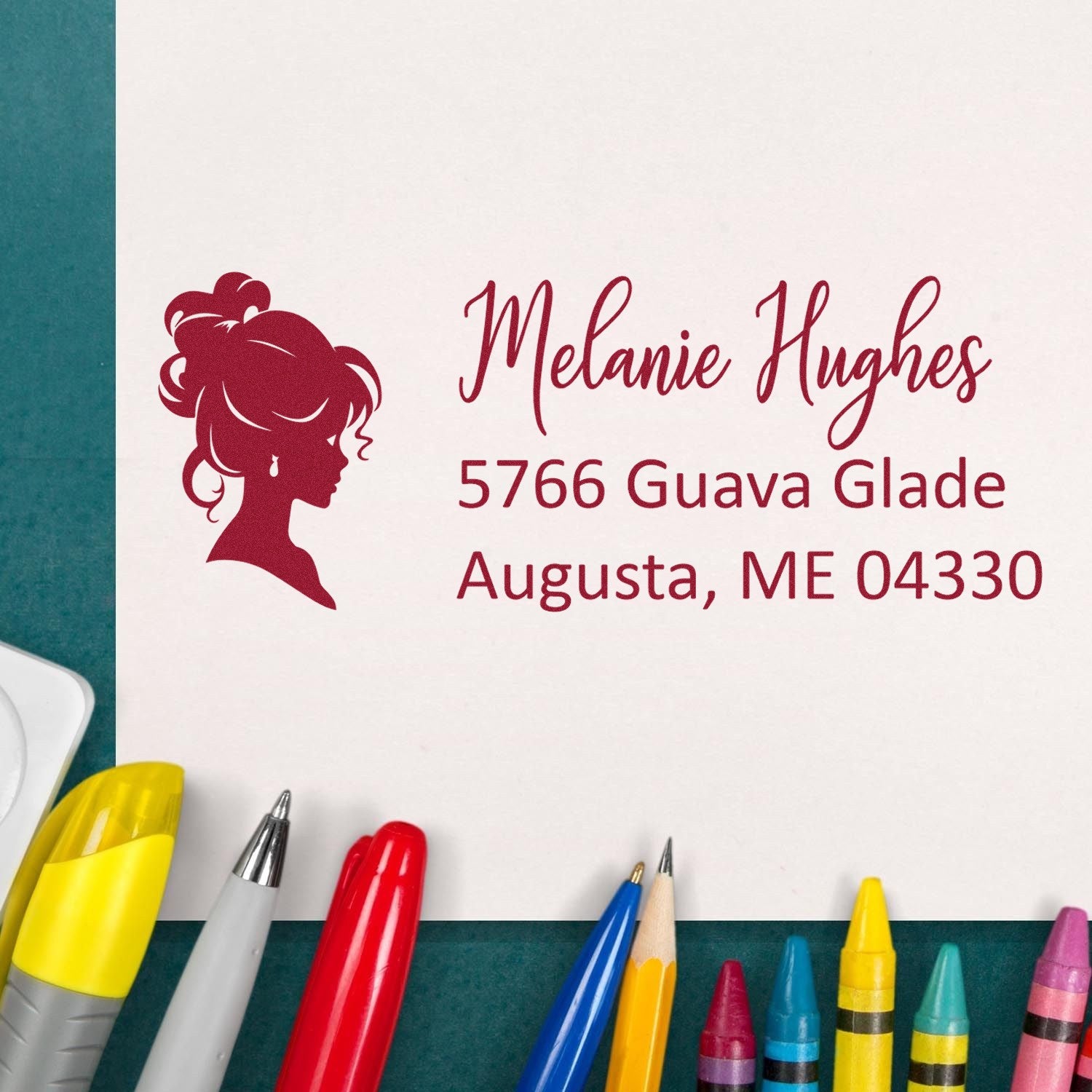 Custom rubber address stamp with female silhouette, featuring Melanie Hughes and Augusta, ME address for personalized mailing labels.