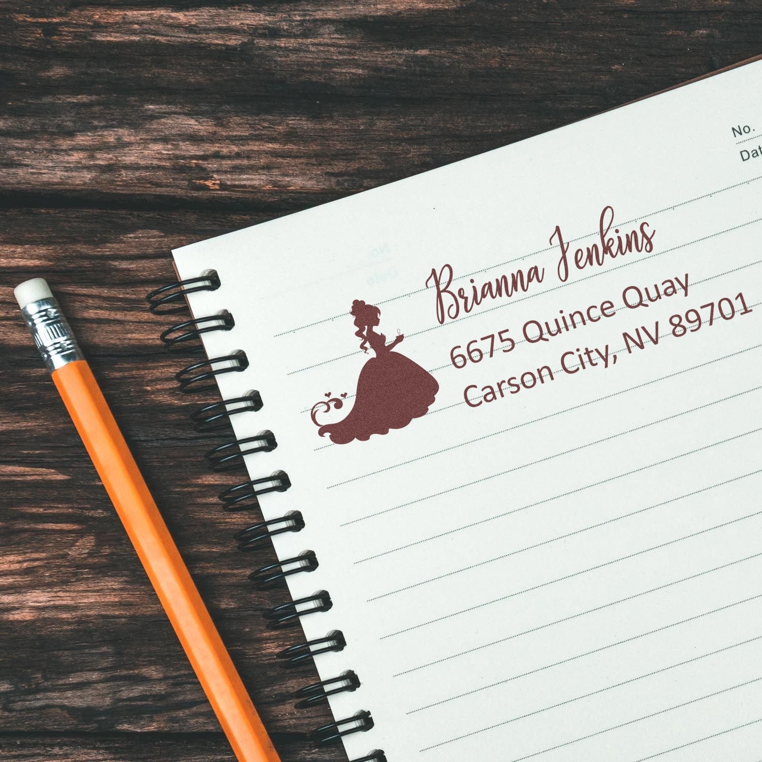 Custom return address rubber stamp with princess silhouette design, featuring name and address on a notebook page