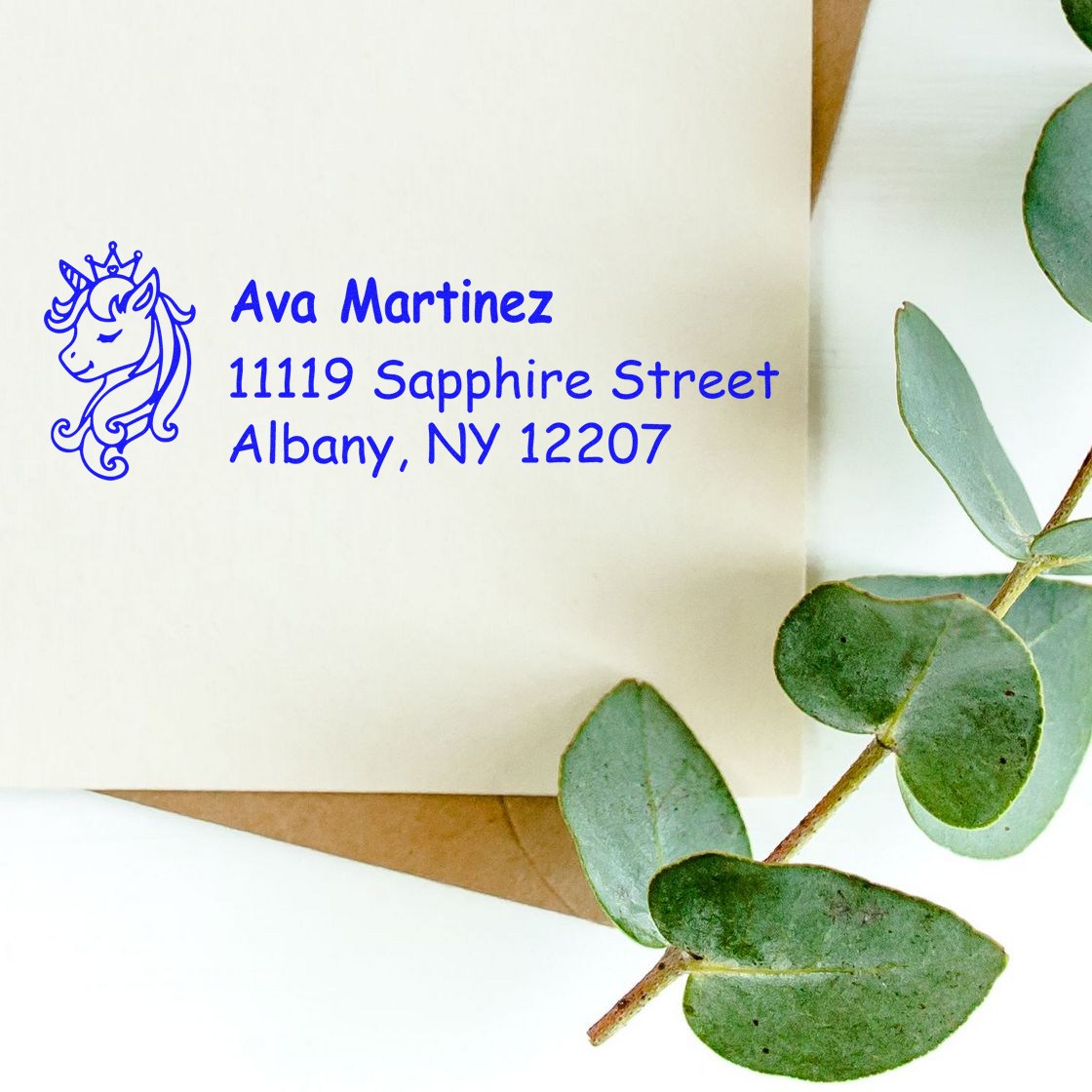 Custom unicorn return address rubber stamp for Ava Martinez, Albany, NY 12207, shown in blue ink on an envelope.