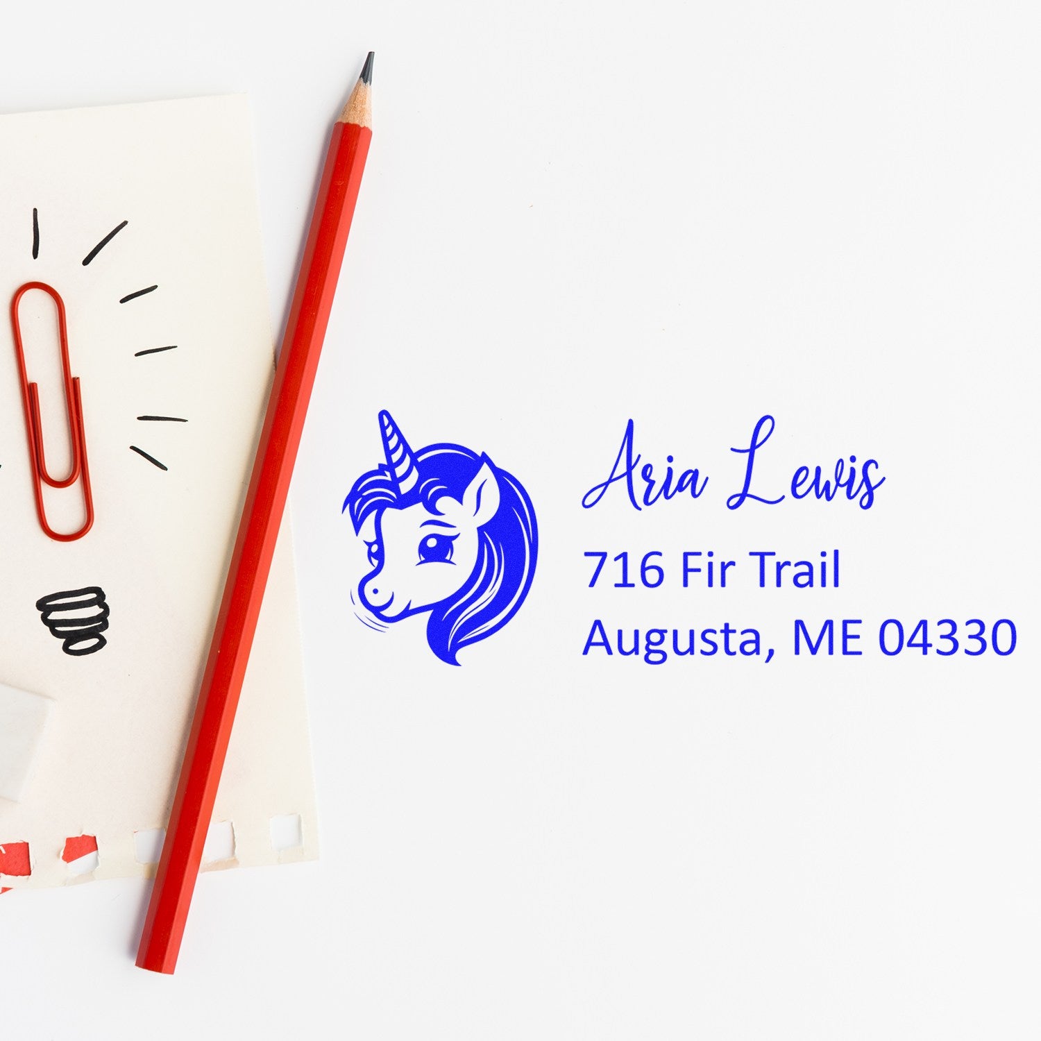 Personalized unicorn return address rubber stamp with name and Augusta, ME address on white paper.