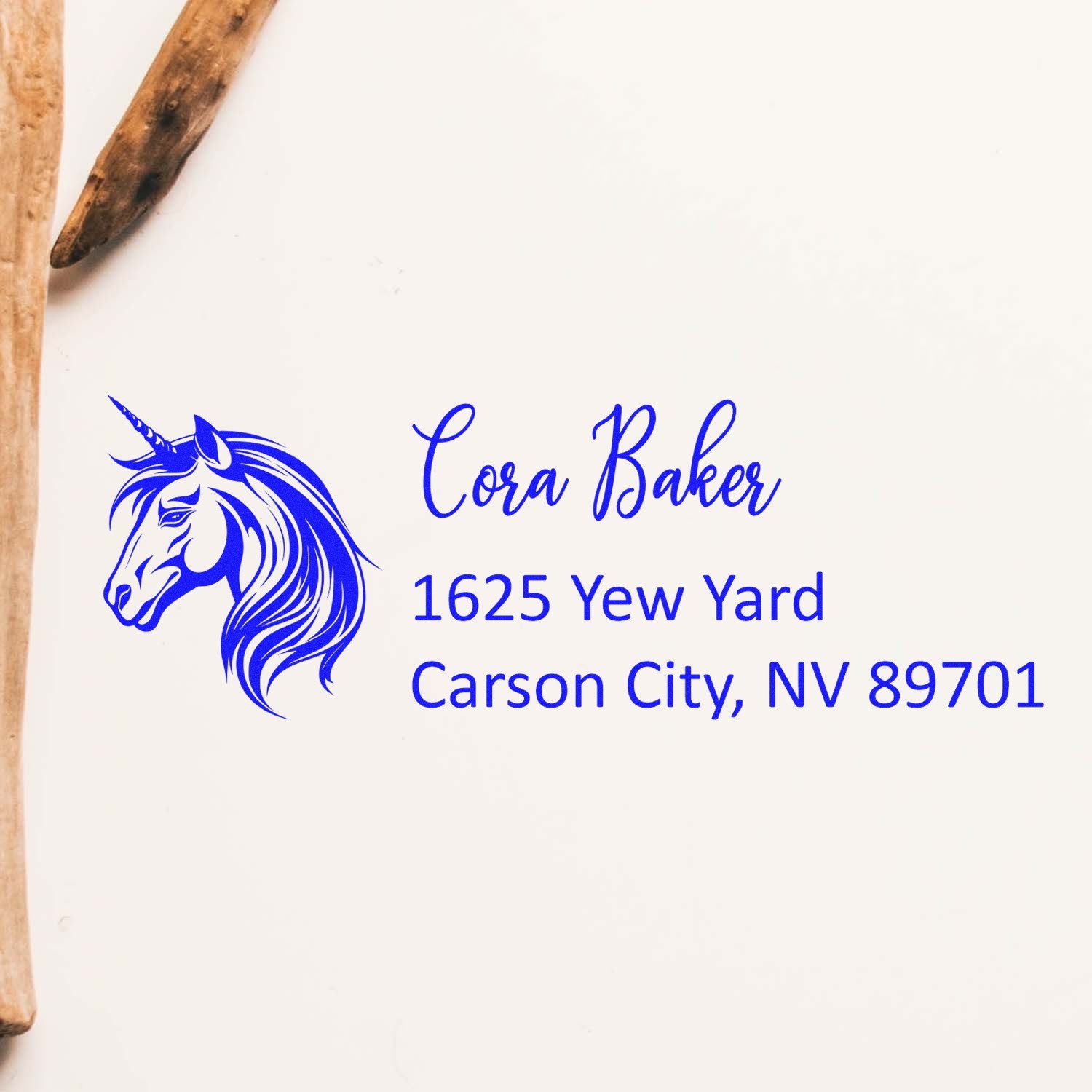Custom unicorn return address rubber stamp with Cora Baker, 1625 Yew Yard, Carson City, NV 89701 in blue ink.