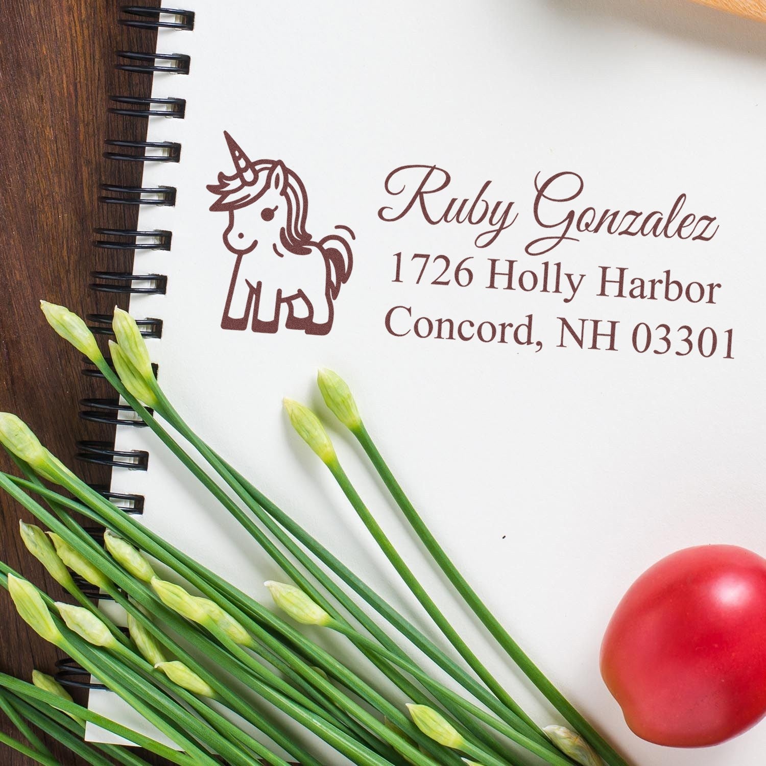 Personalized unicorn return address rubber stamp impression on notebook paper with name and Concord, NH address.
