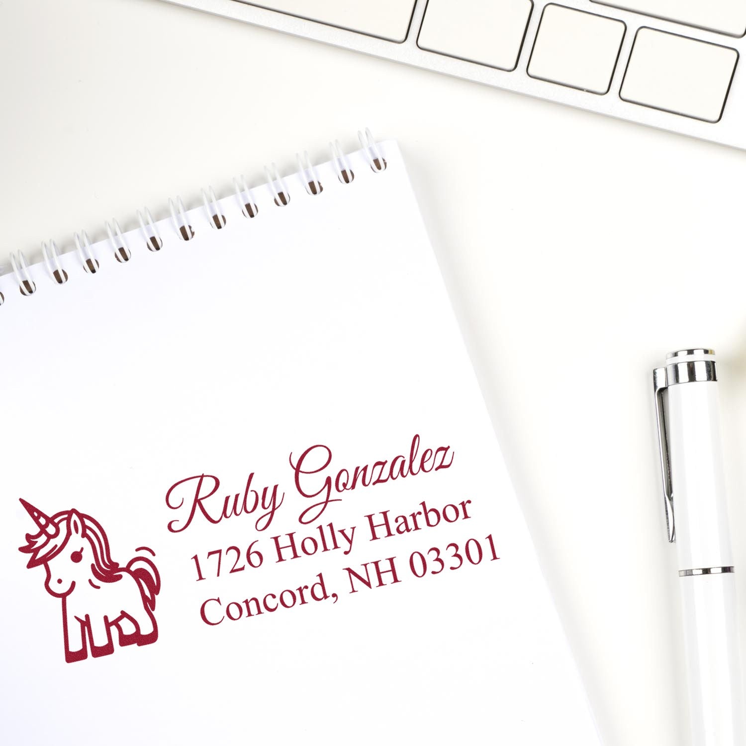 Custom unicorn return address rubber stamp with name and address, stamped on a notepad for personalized mailing.