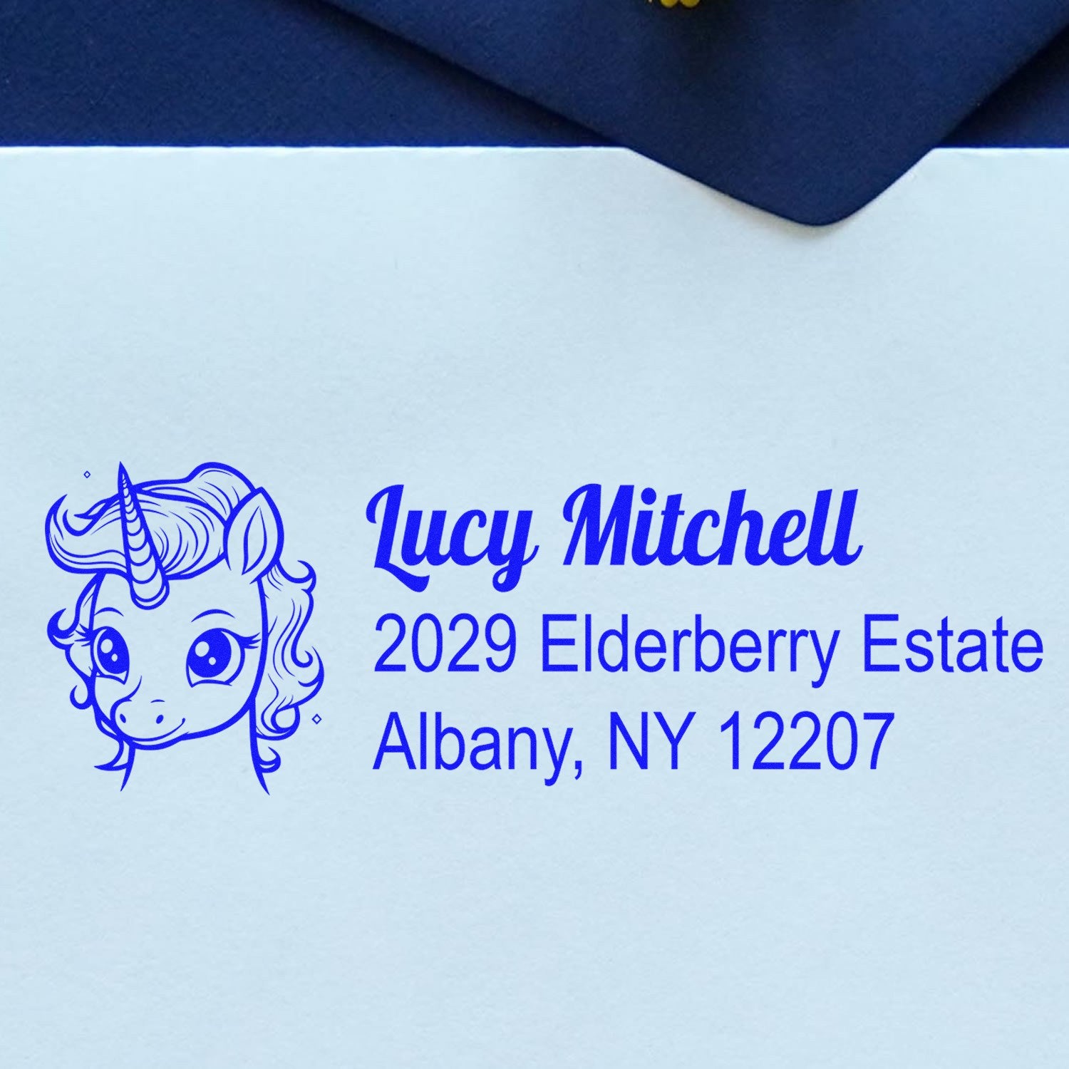 Custom unicorn return address rubber stamp for Lucy Mitchell, 2029 Elderberry Estate, Albany, NY 12207.