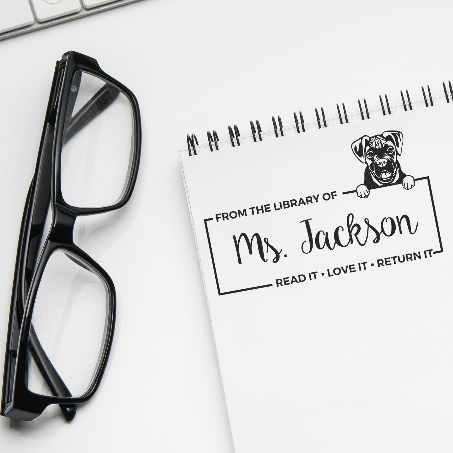 Personalized rubber book stamp for library books reading From the Library of Ms. Jackson with dog icon.