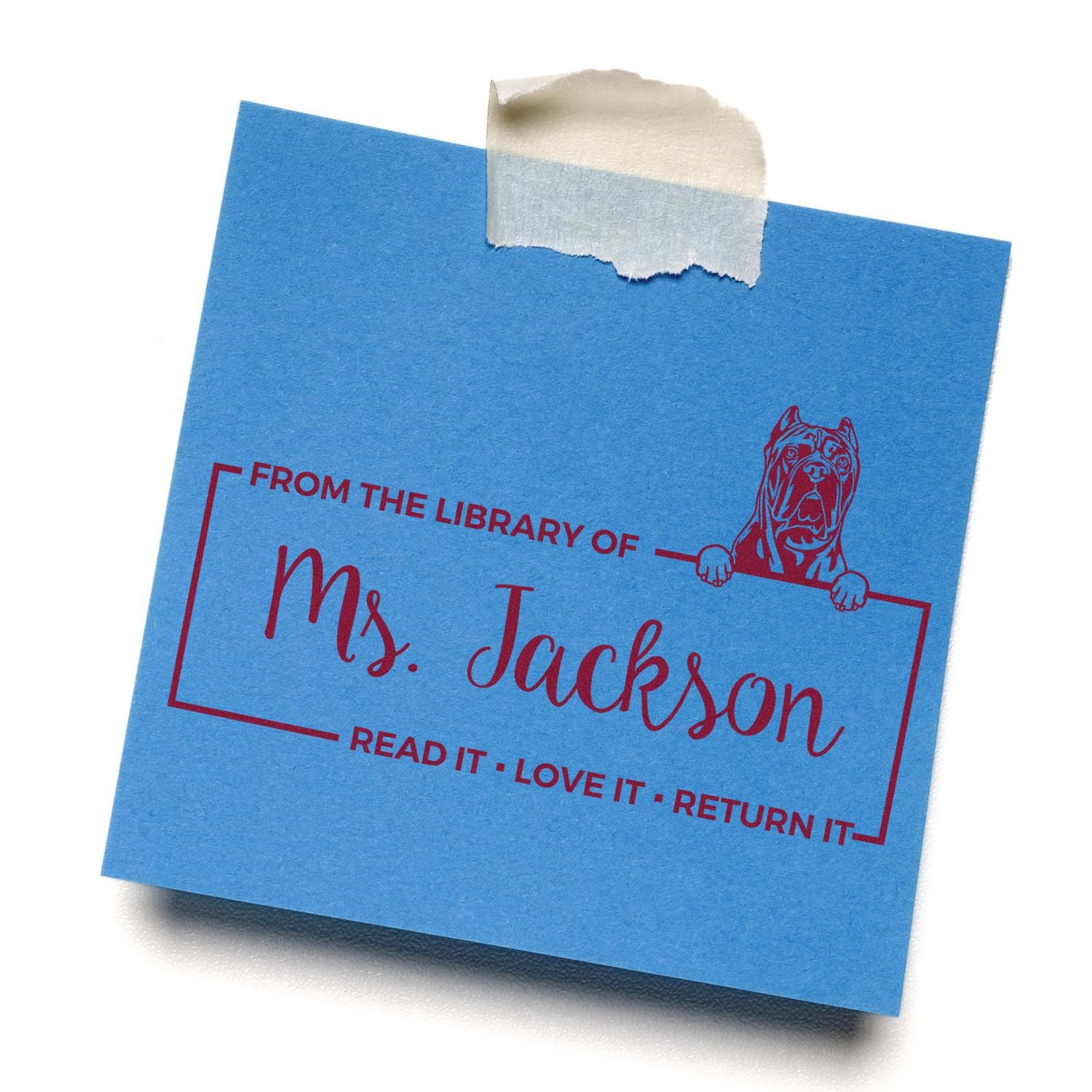 Personalized library rubber stamp on blue card reading From the Library of Ms. Jackson, Read It, Love It, Return It with dog art.