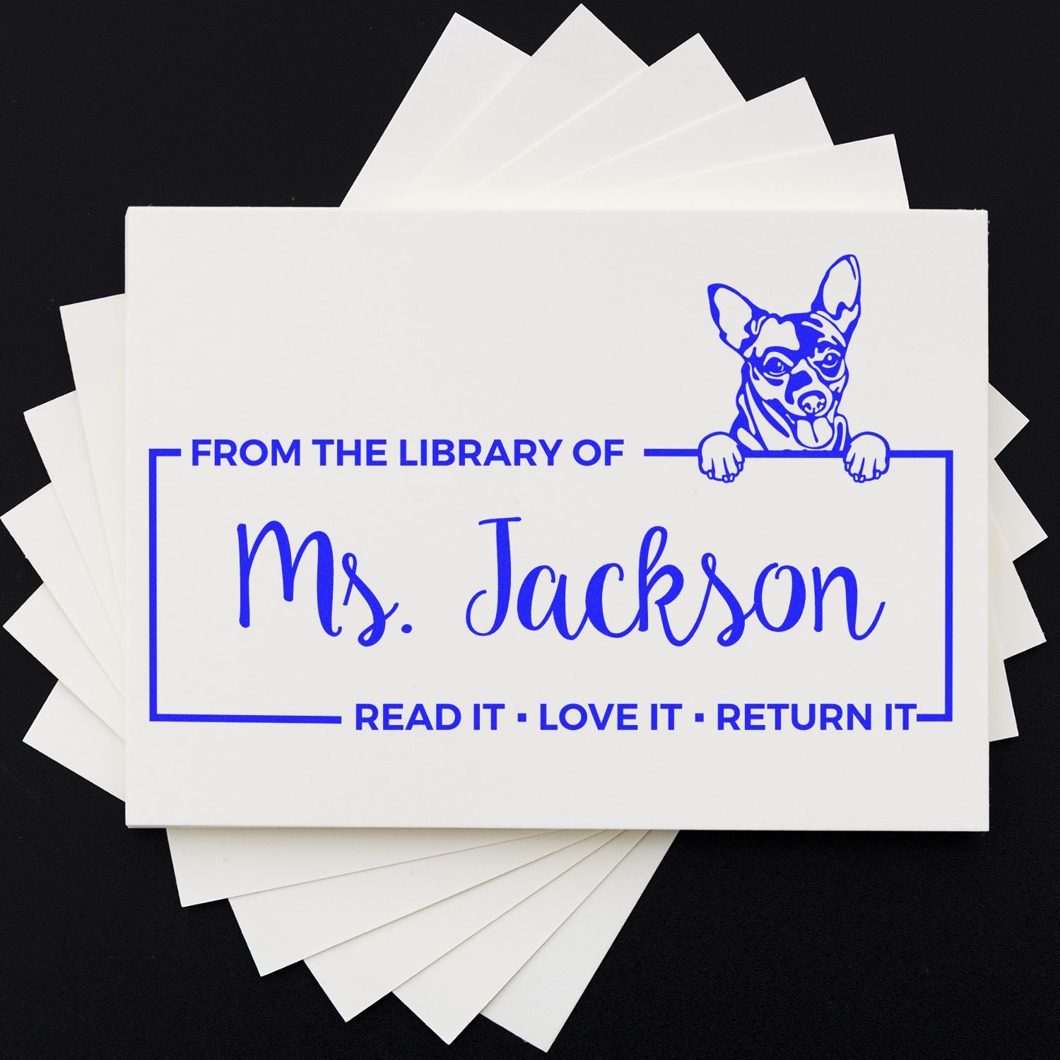 Personalized library rubber stamp for Ms. Jackson with dog graphic and Read it, love it, return it book ownership message.