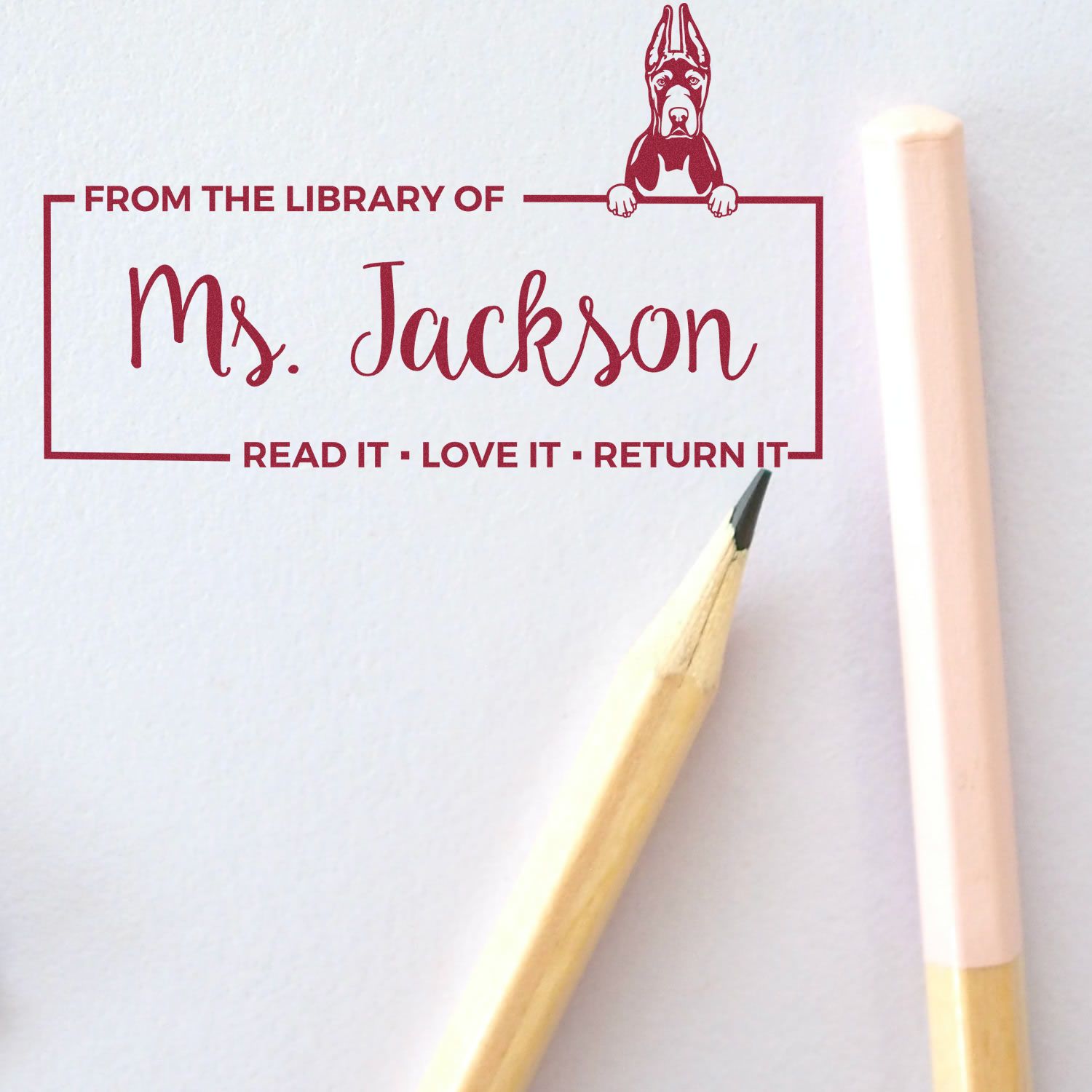 Custom teacher library rubber stamp for books, featuring Ms. Jackson name, dog bookplate art, and Read It Love It Return It message.