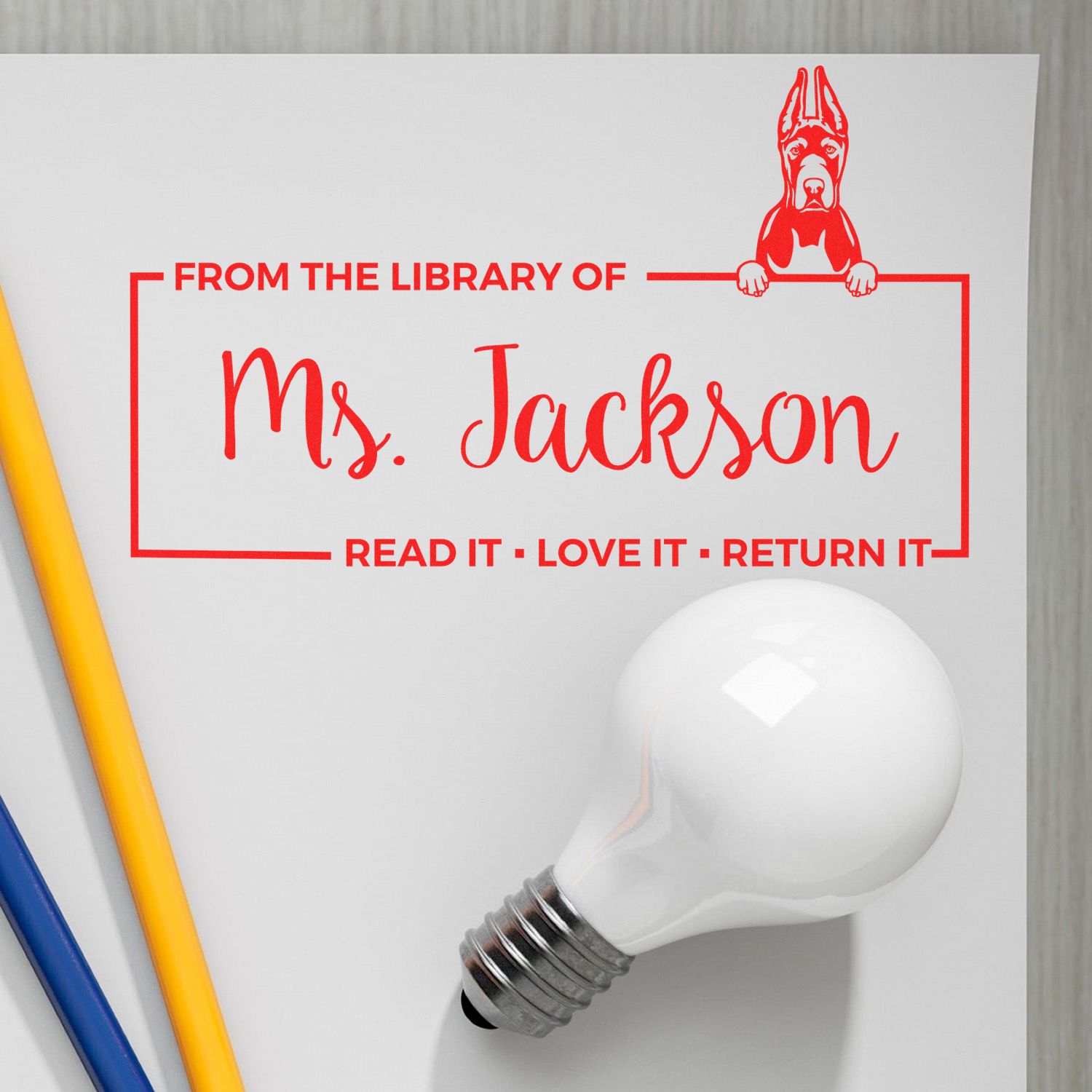Personalized library rubber stamp for Ms. Jackson, with dog design and Read It, Love It, Return It book return message.