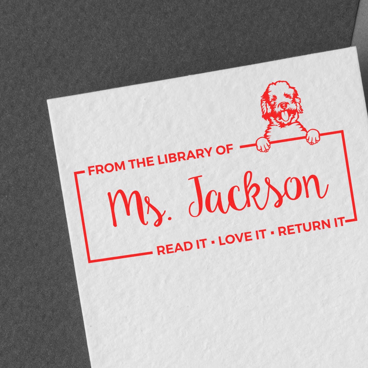 Custom rubber stamp for library books reading From the Library of Ms. Jackson with dog illustration and return-it message.