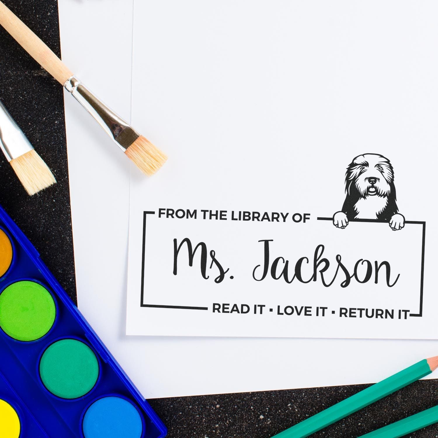 Custom library rubber stamp for Ms. Jackson with dog design and Read It, Love It, Return It message for book labels.