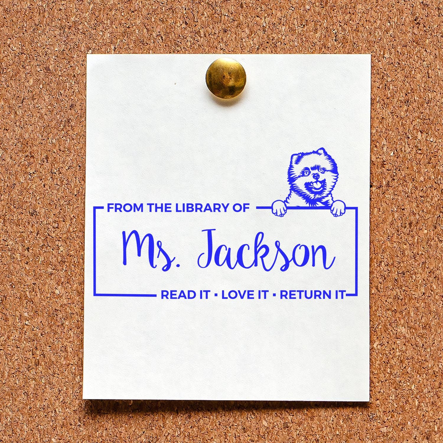Custom rubber library book stamp for Ms. Jackson with dog illustration and Read It, Love It, Return It on pinned paper.