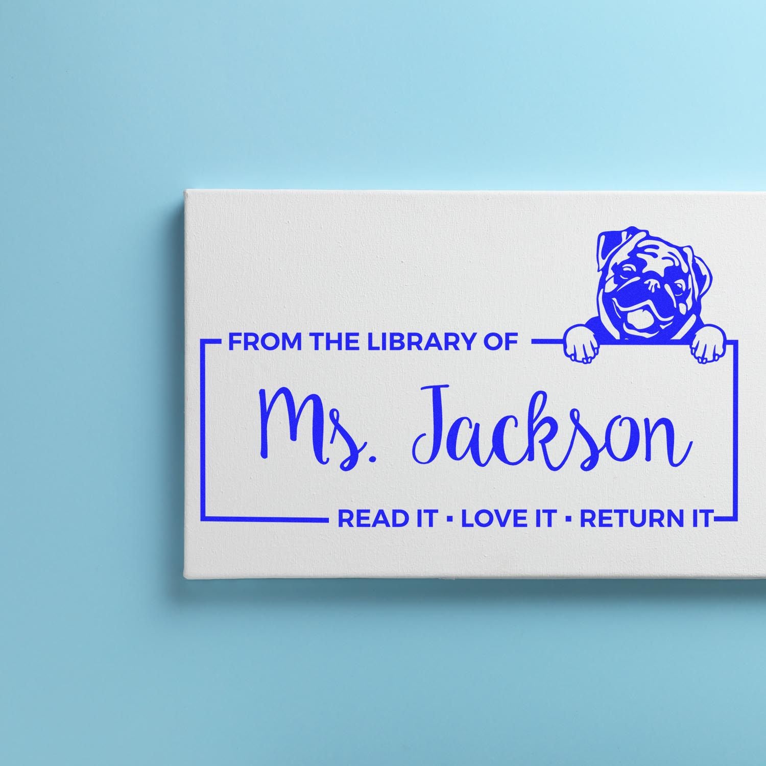 Personalized library rubber stamp for Ms. Jackson, featuring bulldog art and a Read it, love it, return it book label.