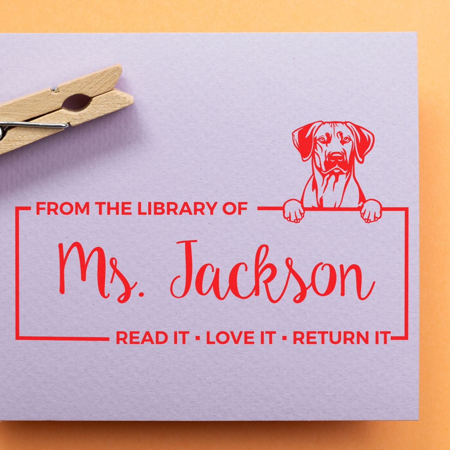 Personalized library rubber stamp for Ms. Jackson with dog bookplate design and Read it, love it, return it message.