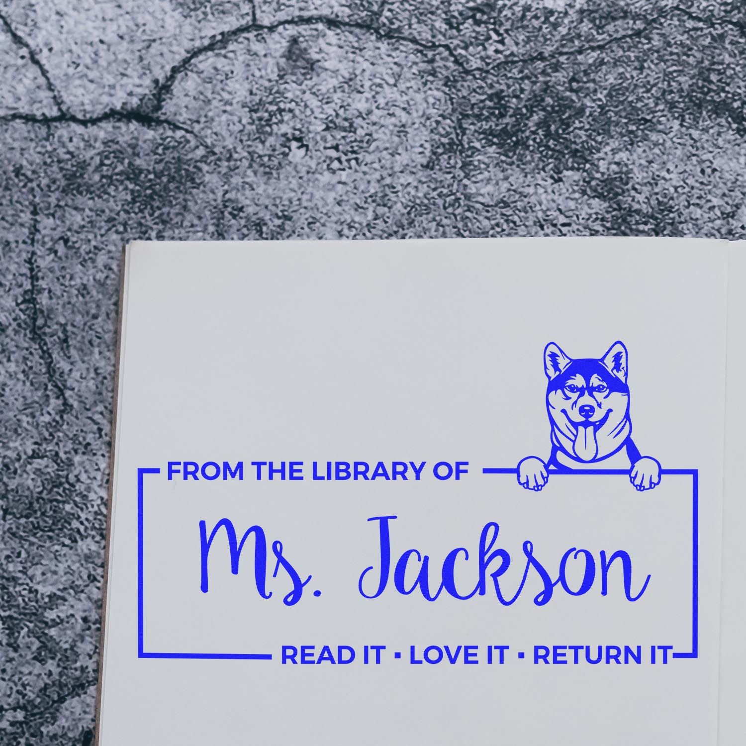 Personalized rubber stamp for books reading From the Library of Ms. Jackson with dog mascot.