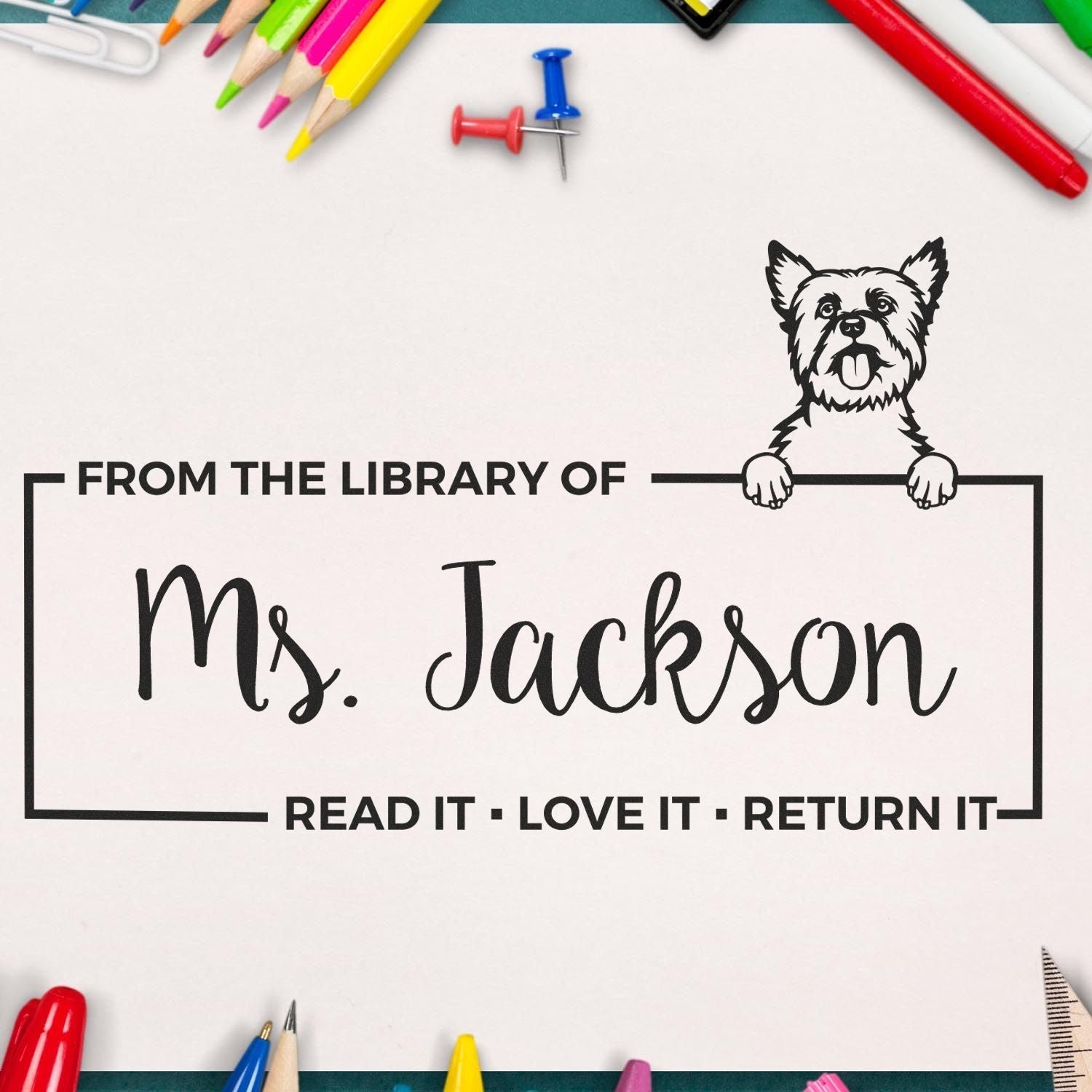 Personalized library rubber stamp for Ms. Jackson with dog mascot and Read it, Love it, Return it book return message.