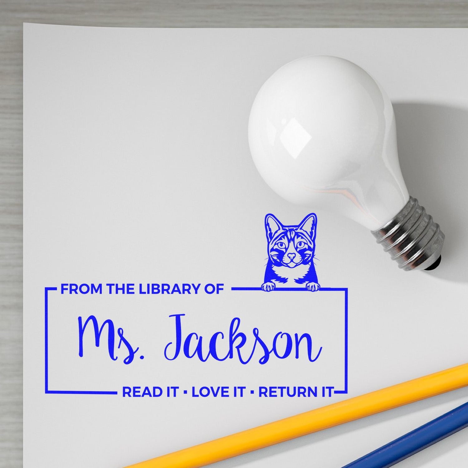 Custom rubber book stamp mockup for Ms. Jackson, featuring cat design and From the Library of return-it message on white paper.
