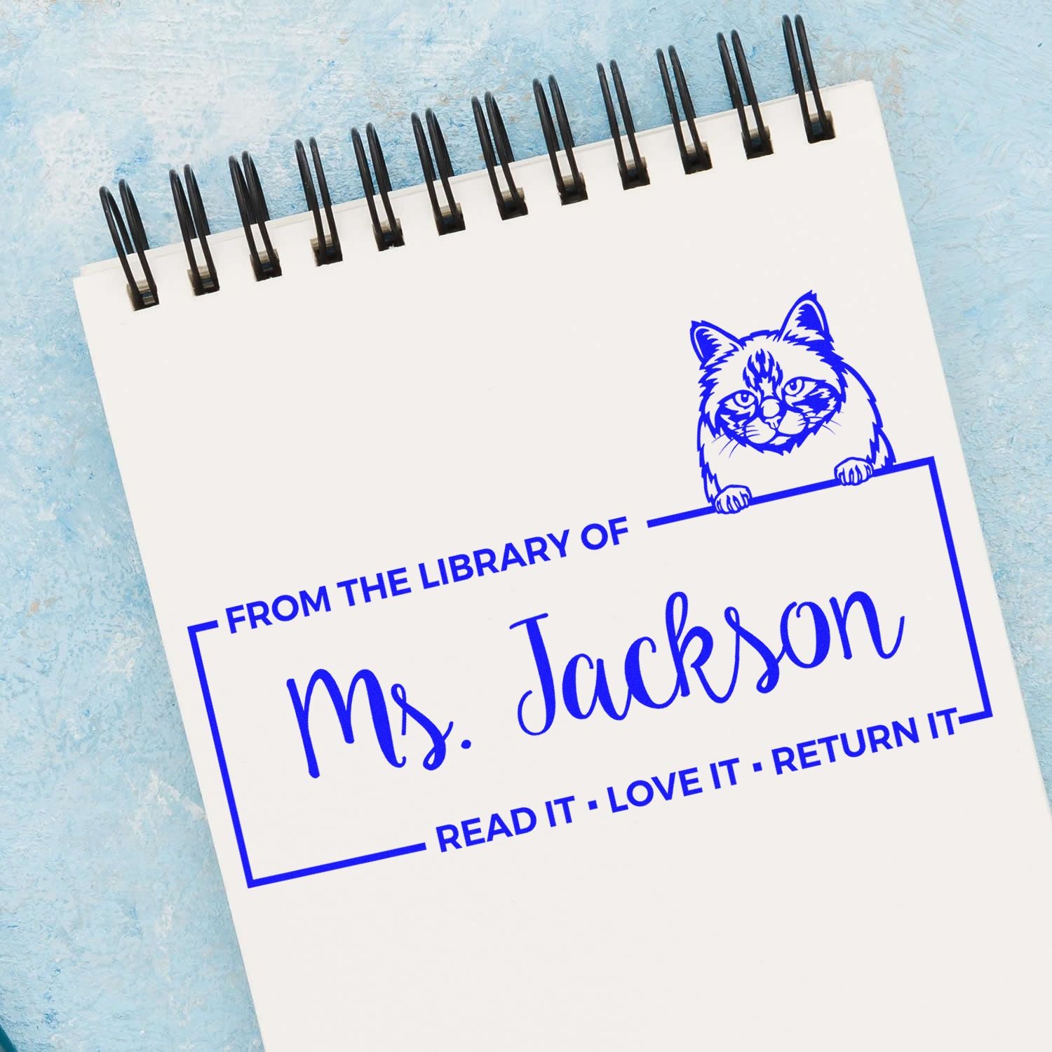 Personalized library rubber stamp with cat design reading From the Library of Ms. Jackson and Read it, love it, return it.