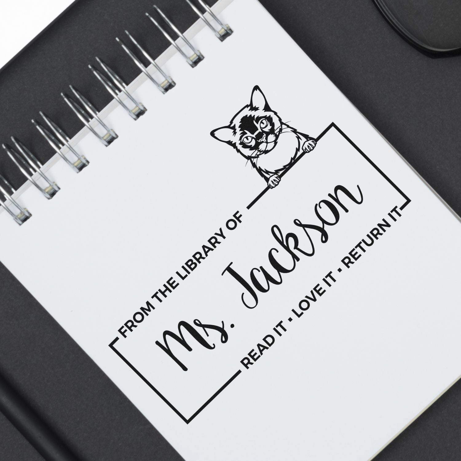 Custom teacher library rubber stamp with cat design and From the Library of Mrs. Jackson book return message.