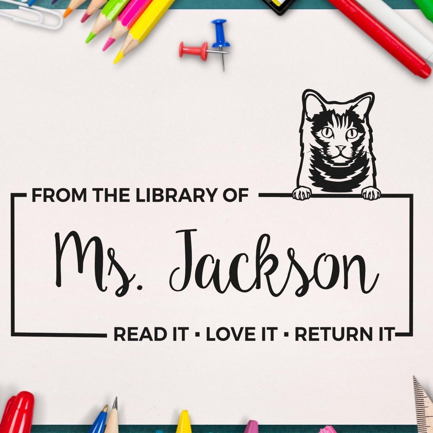 Personalized rubber stamp for library books, featuring cat design and Ms. Jackson name, with Read it, Love it, Return it message.