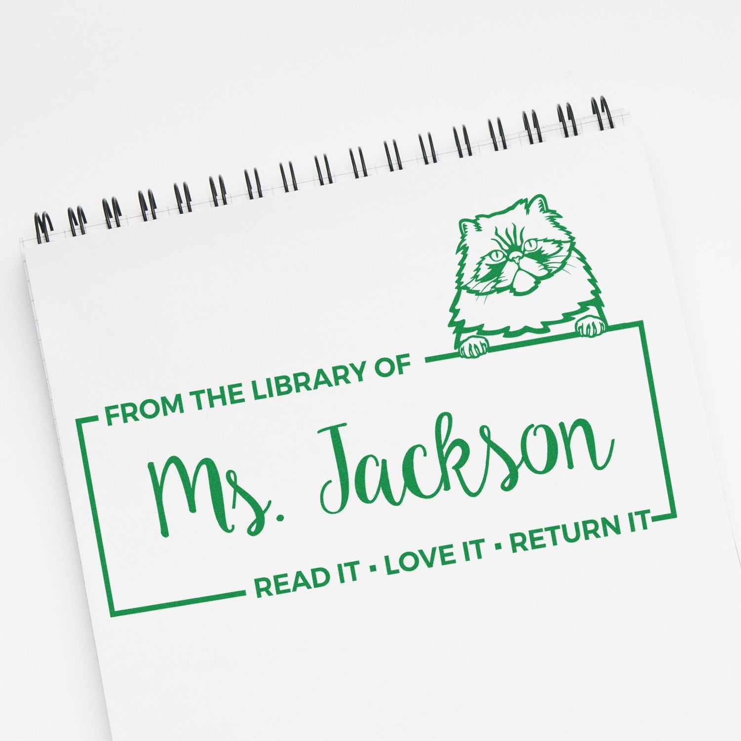 Personalized library rubber stamp for Ms. Jackson, featuring a cat and Read it, love it, return it book label.