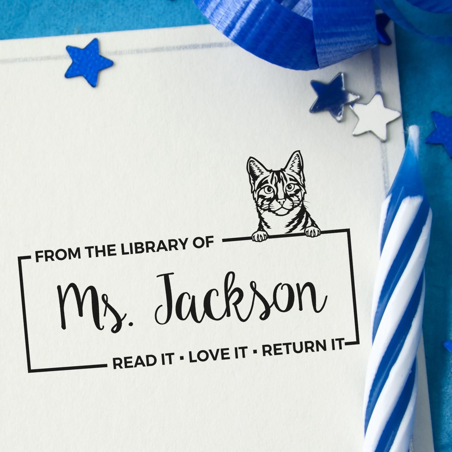 Personalized library rubber stamp for Ms. Jackson with cat graphic and Read It, Love It, Return It book return message.
