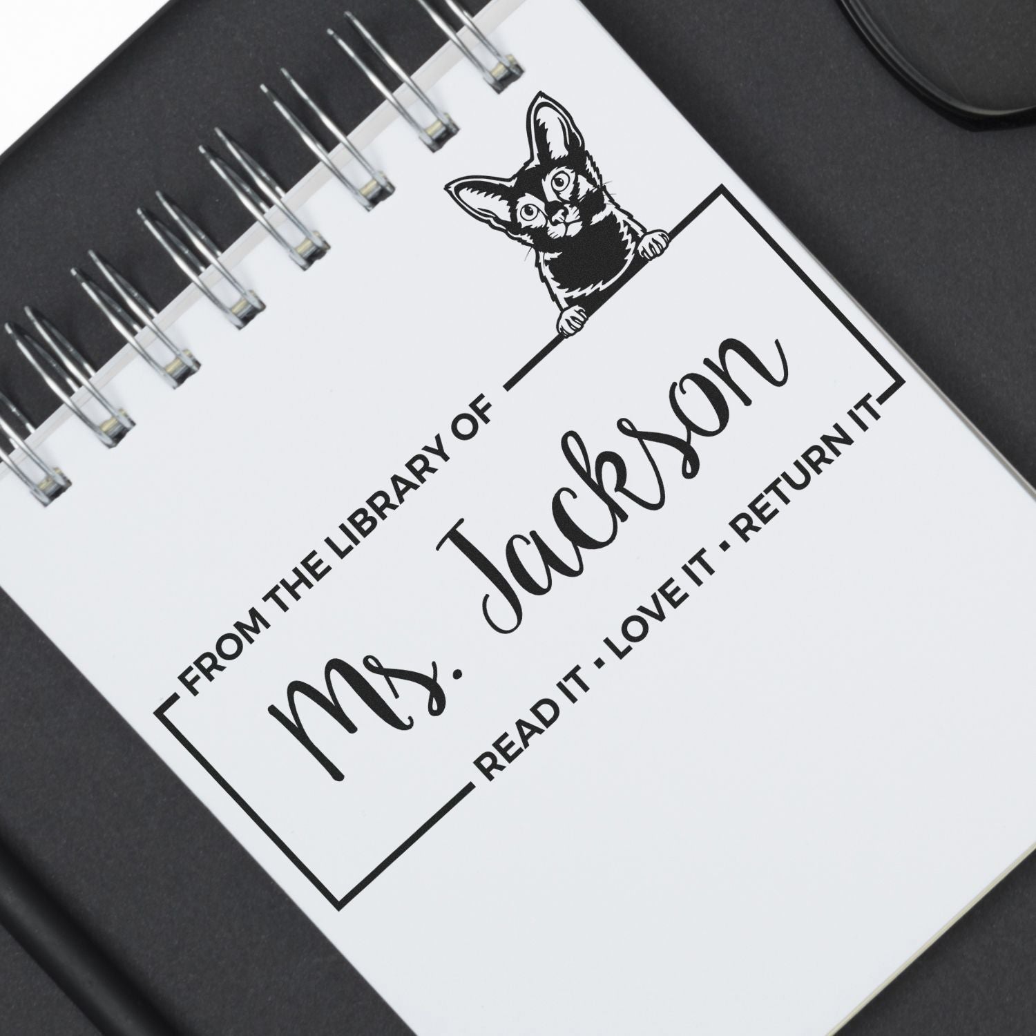 Custom teacher bookplate rubber stamp reading From the library of Mrs. Jackson with cat illustration and return-it message.