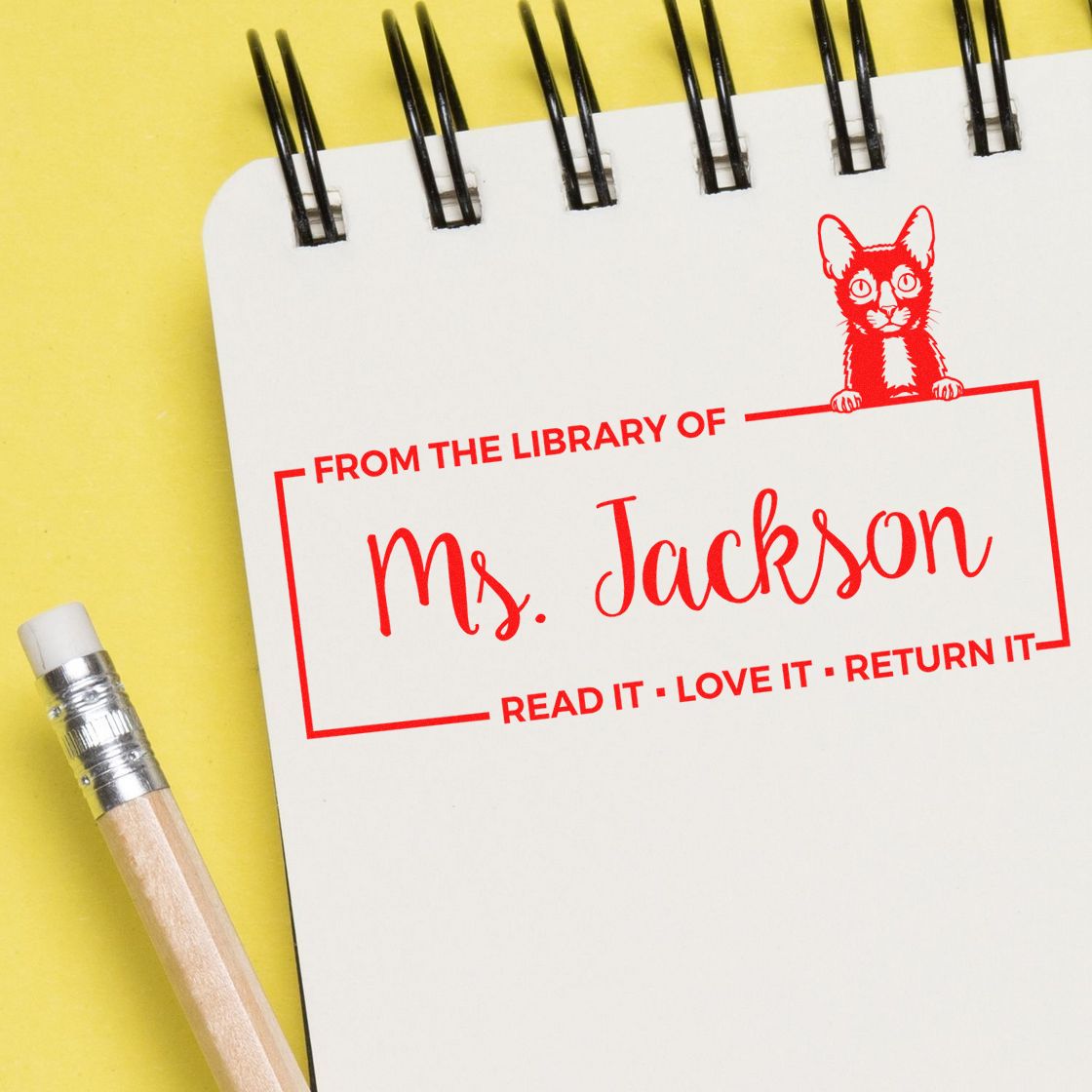 Personalized book rubber stamp with cat design, reading From the Library of Ms. Jackson for teacher book labeling.