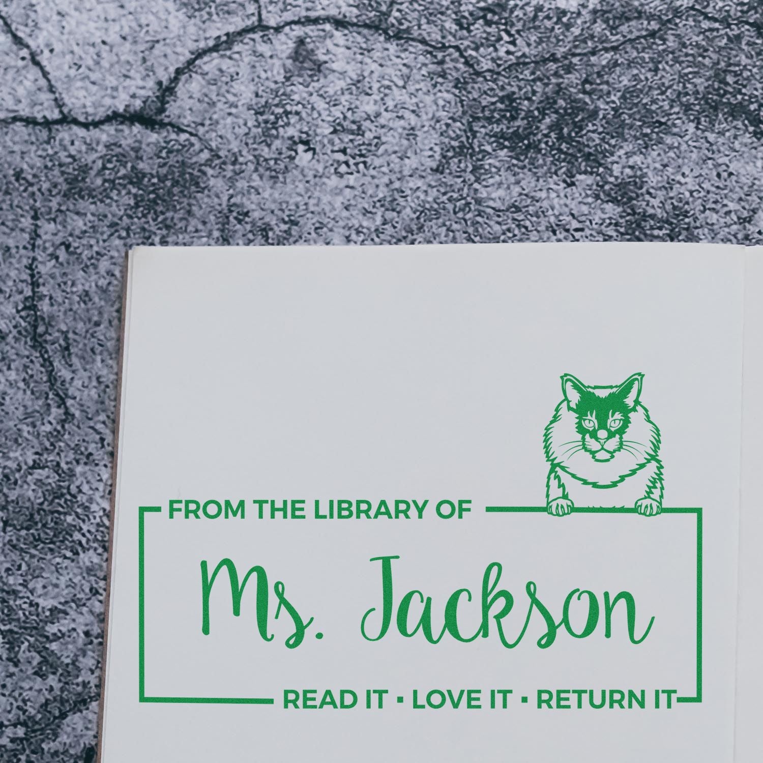 Personalized library rubber stamp for Ms. Jackson with cat design and Read it, Love it, Return it book ownership message.
