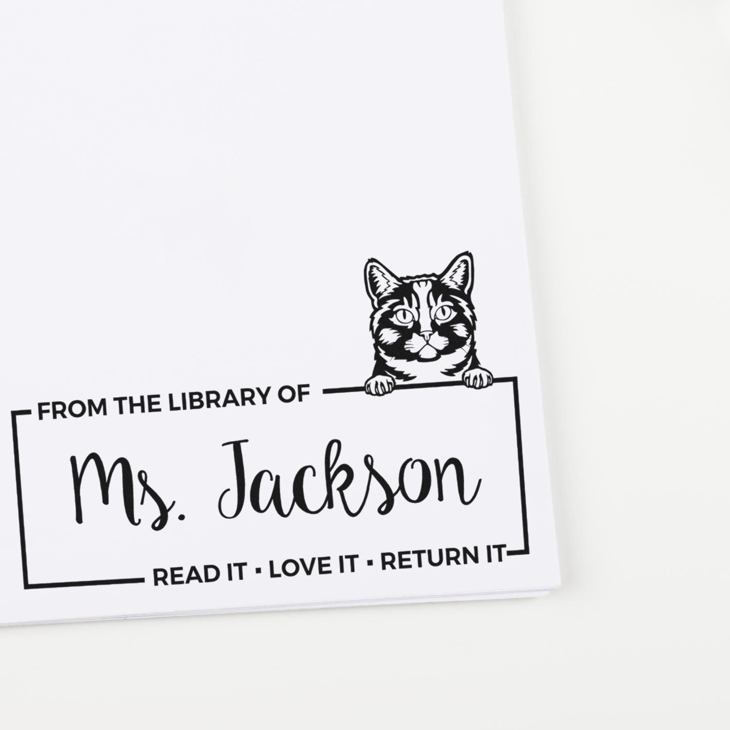 Personalized cat library rubber stamp for Ms. Jackson, with Read it, love it, return it custom bookplate design.