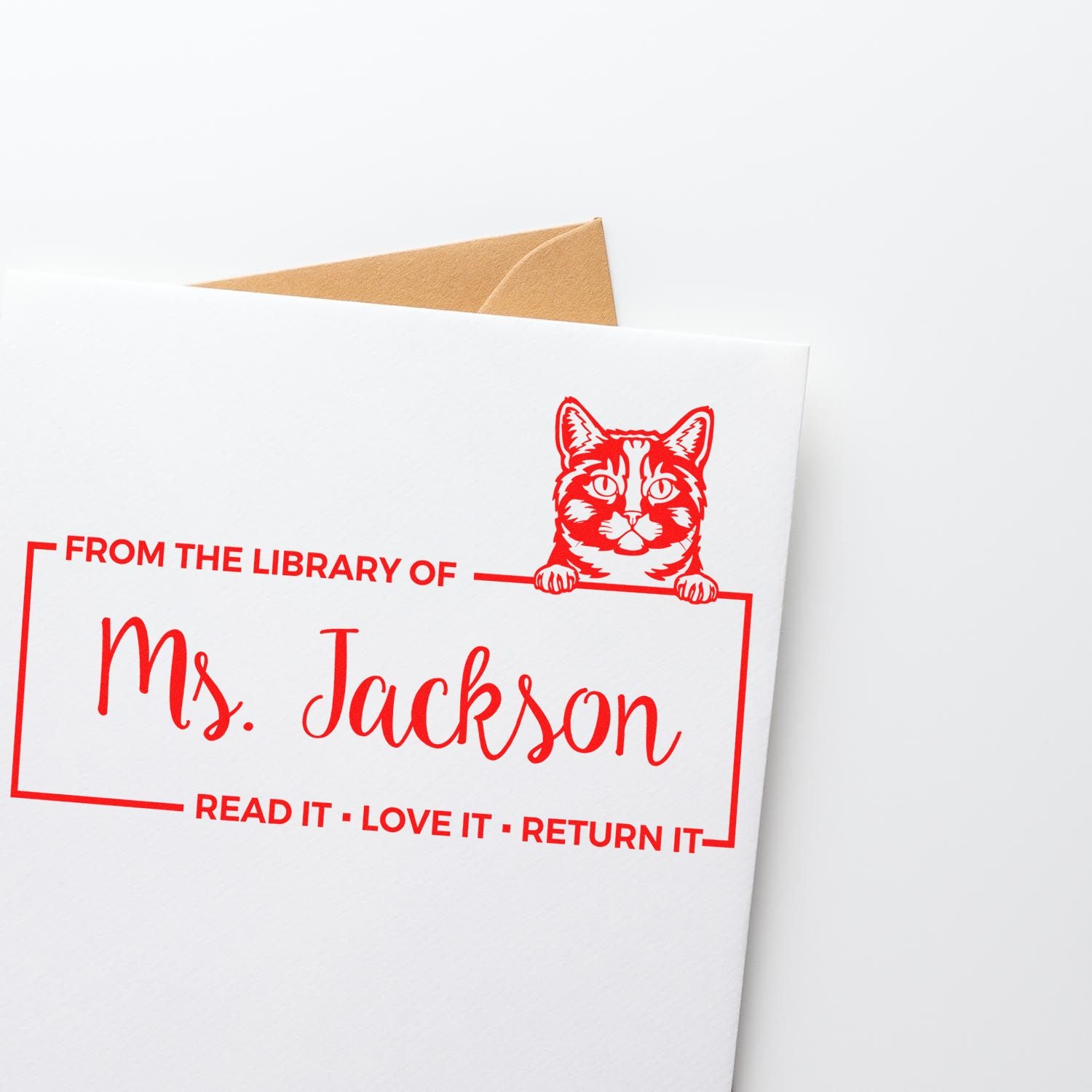 Personalized cat library rubber stamp for books and envelopes, reading From the Library of Ms. Jackson with return-it message.