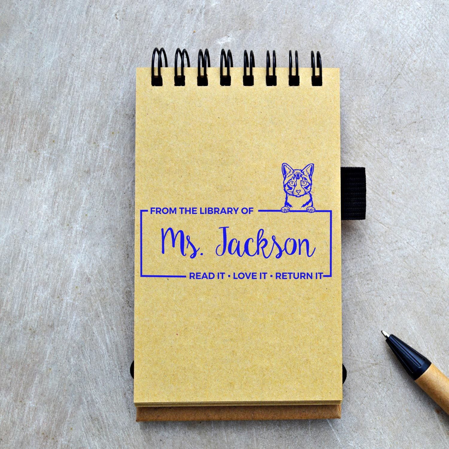 Personalized library rubber stamp on notebook: From the Library of Ms. JacksonRead It, Love It, Return It with cat design.