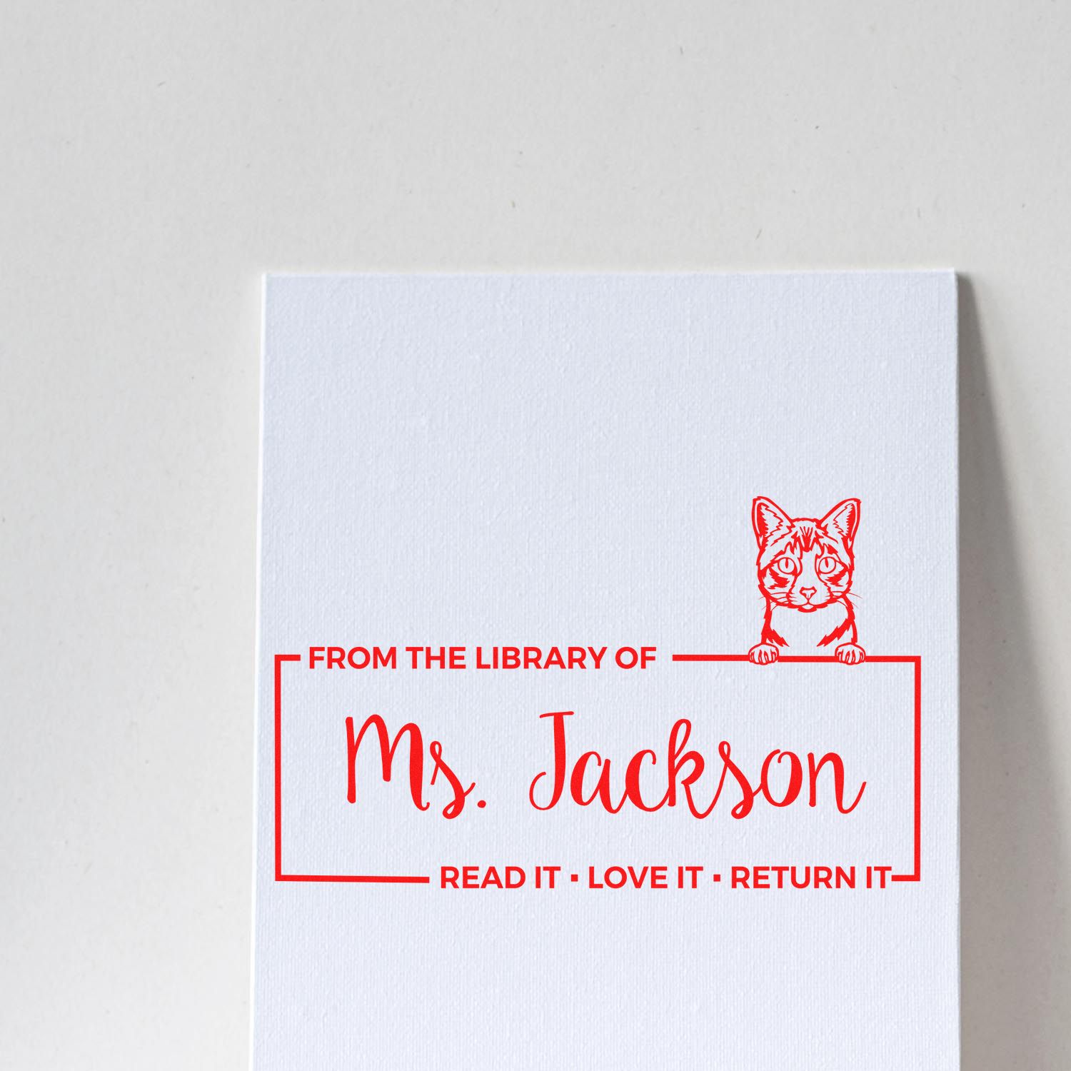 Custom library book stamp for Ms. Jackson with cat design and Read it, love it, return it message.